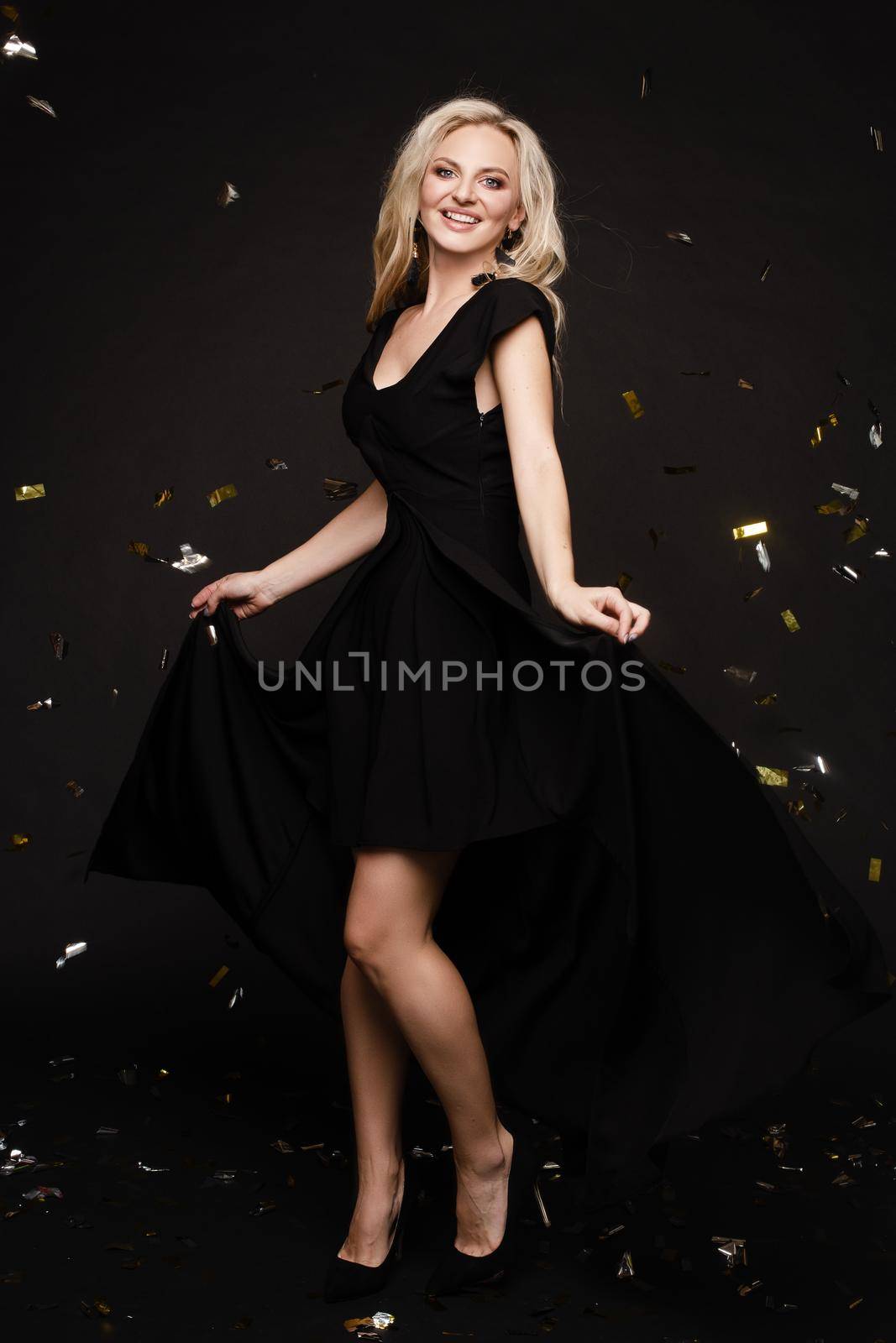 Elegant woman in long black dress posing in studio by StudioLucky
