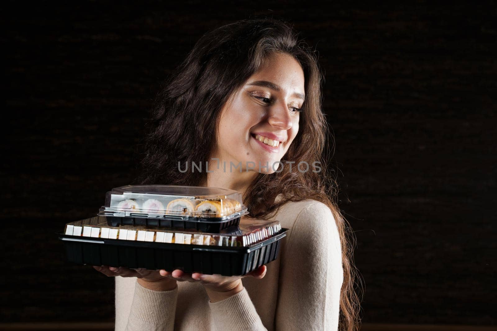 Girl with sushi. Food courier holding 2 sushi boxes . Delivery at quarantine coronavirus covid-19.