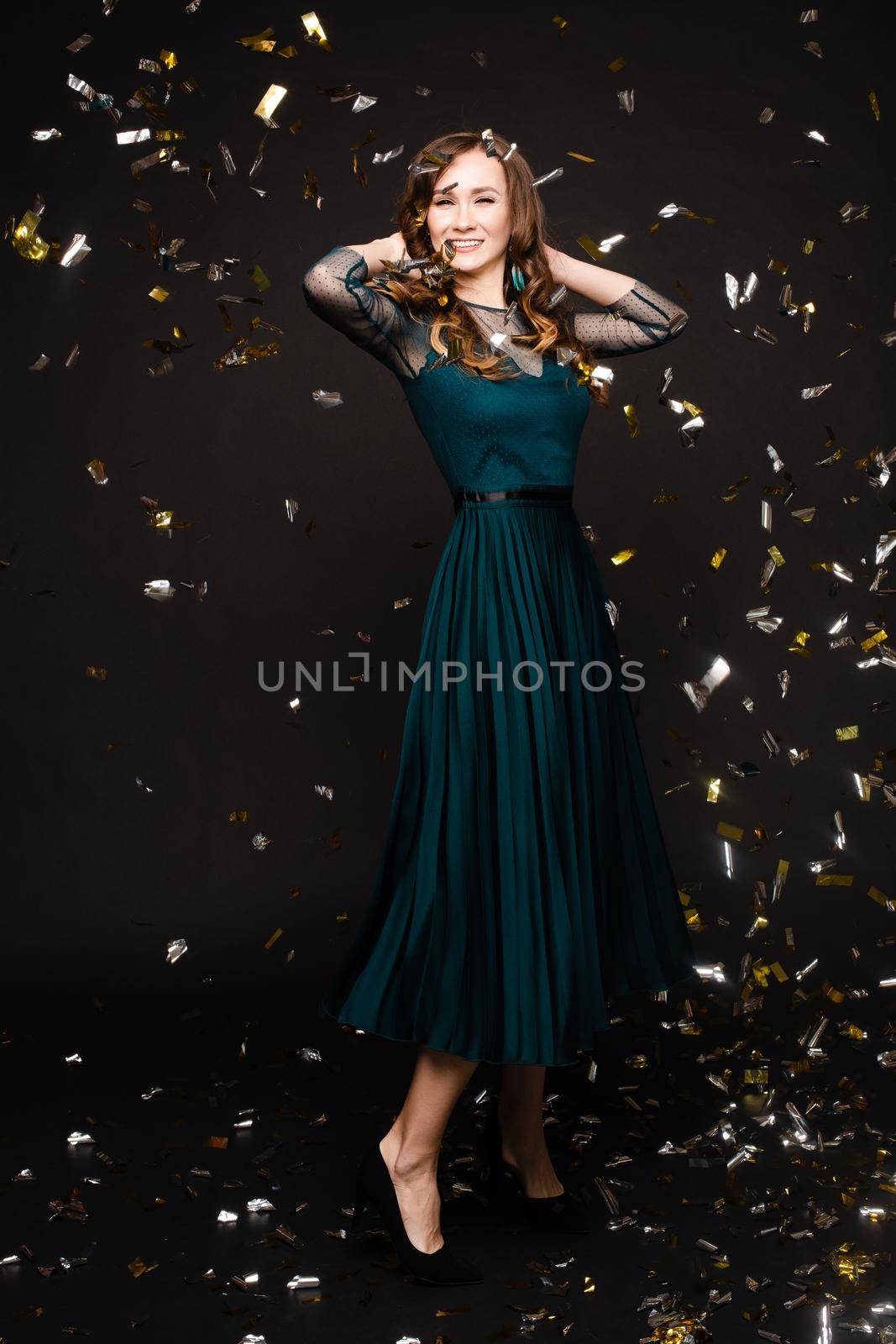 Elegant woman in long black dress posing in studio by StudioLucky