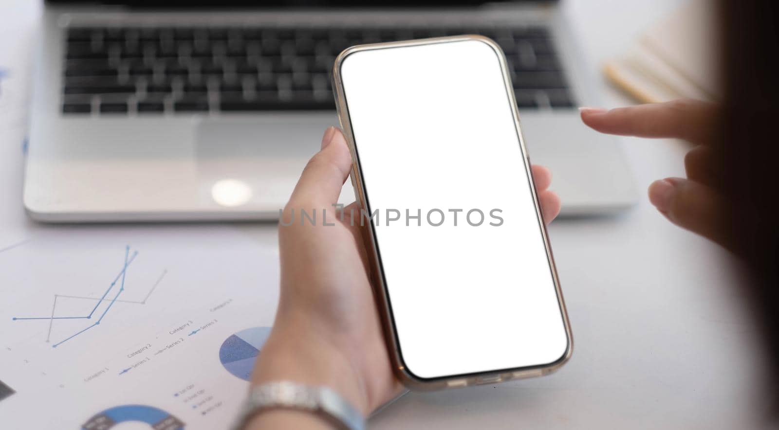 Cropped shot view of woman hands holding smart phone with blank copy space screen for your text message or information content, female reading text message on cell telephone during in office. by wichayada