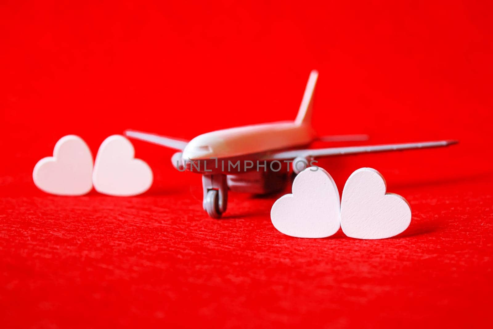 Hearts and a plane on a red background. Valentine's Day. Selective focus. by mila1784