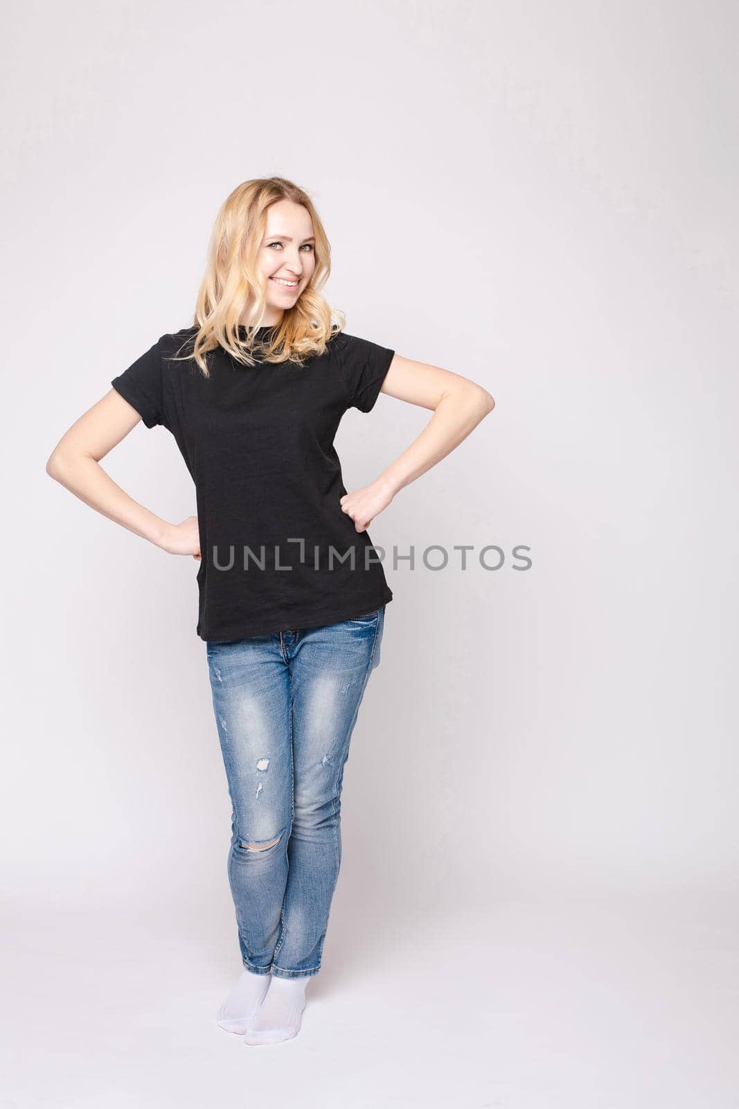 Studio portrait of unsatisfied young brunette caucasian woman with wavy hair in overall with colorful pattern holding arms folded and looking at camera with grief, dissatisfaction, anger and disbelief. Isolate.