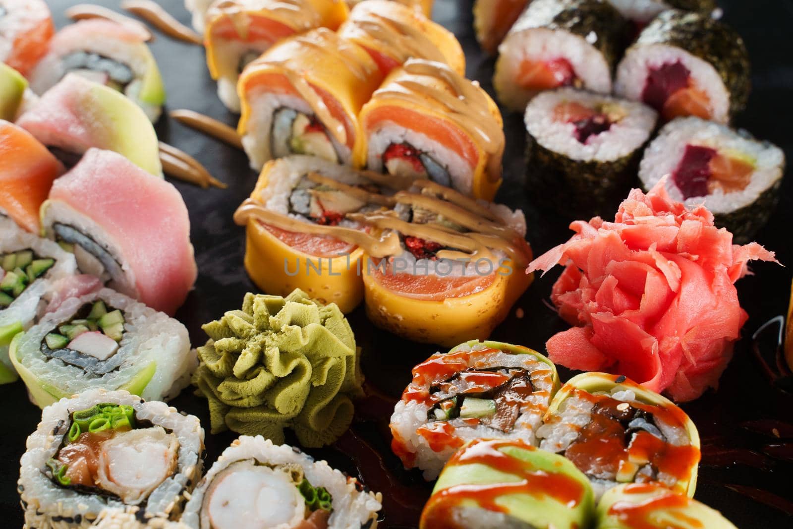 Sushi set close-up on black background. Traditional Japanese seafood. Delicious roll. Advert for food delivery service