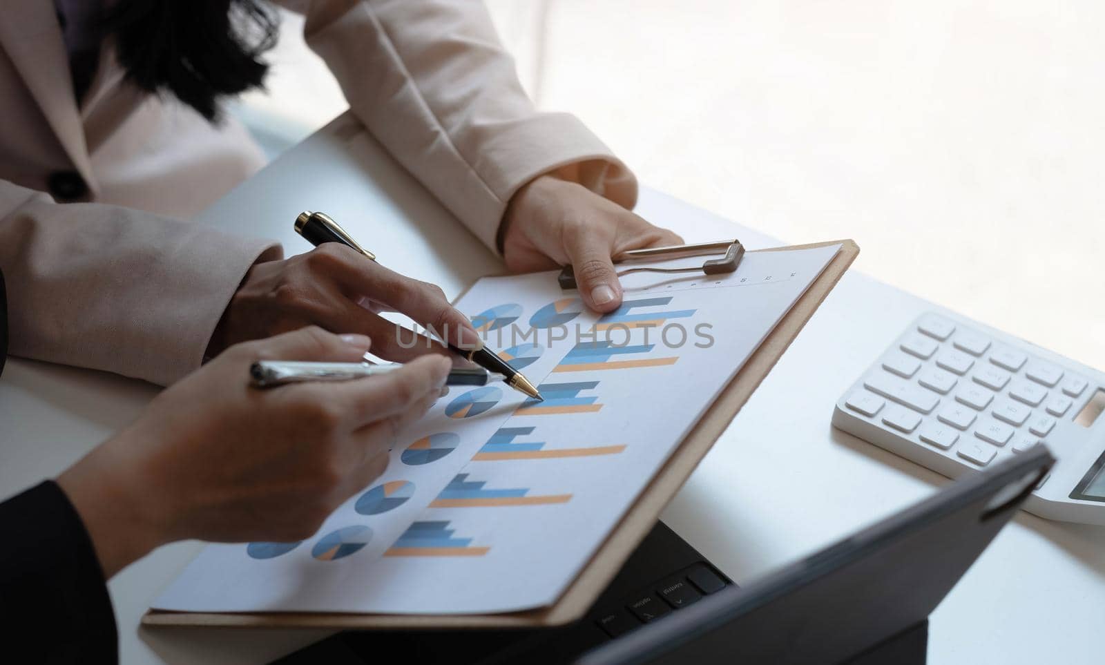 Business people pointing financial data graph on the table in the meeting room. by wichayada