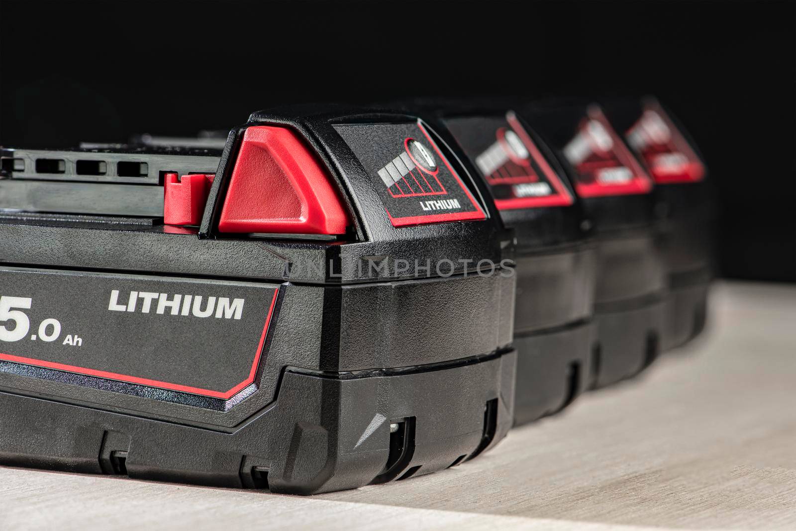 Battery for cordless drill. Screwdriver battery. Four batteries with a charge indicator on a black background.