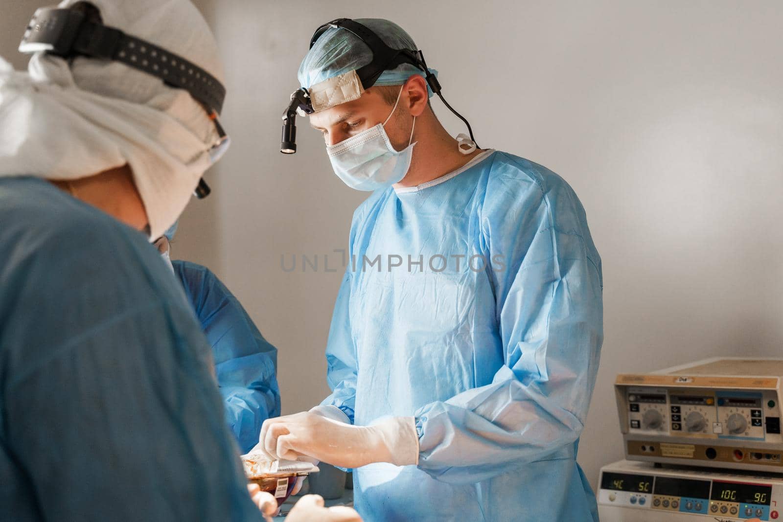 Surgeon open box and takes silicone implant. Chest augmentation plastic operation in medical clinic. Surgeon insert silicone implant in chest of woman