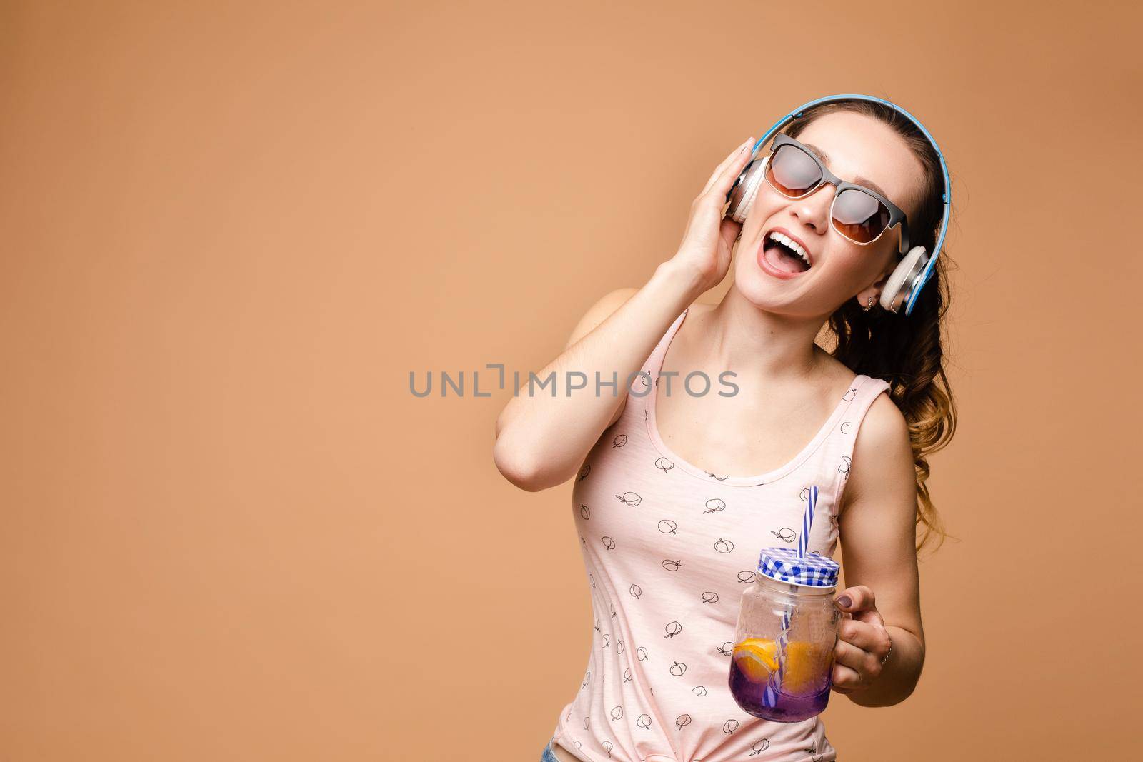 Brunette young lady singing and drinking tasty lemonade. by StudioLucky