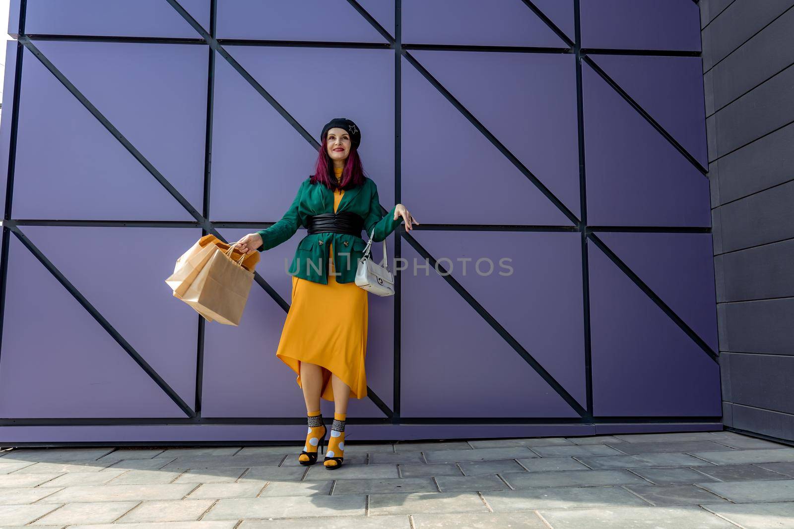 A happy shopaholic girl throws her bags near a shopping center. Have fun shopping on Black Friday. the girl in the store is happy with her purchases, throws packages. Consumer concept