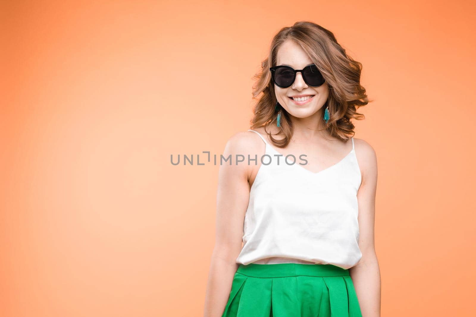 Fashionable young woman in sunglasses. Studio portrait of beautiful caucasian by StudioLucky