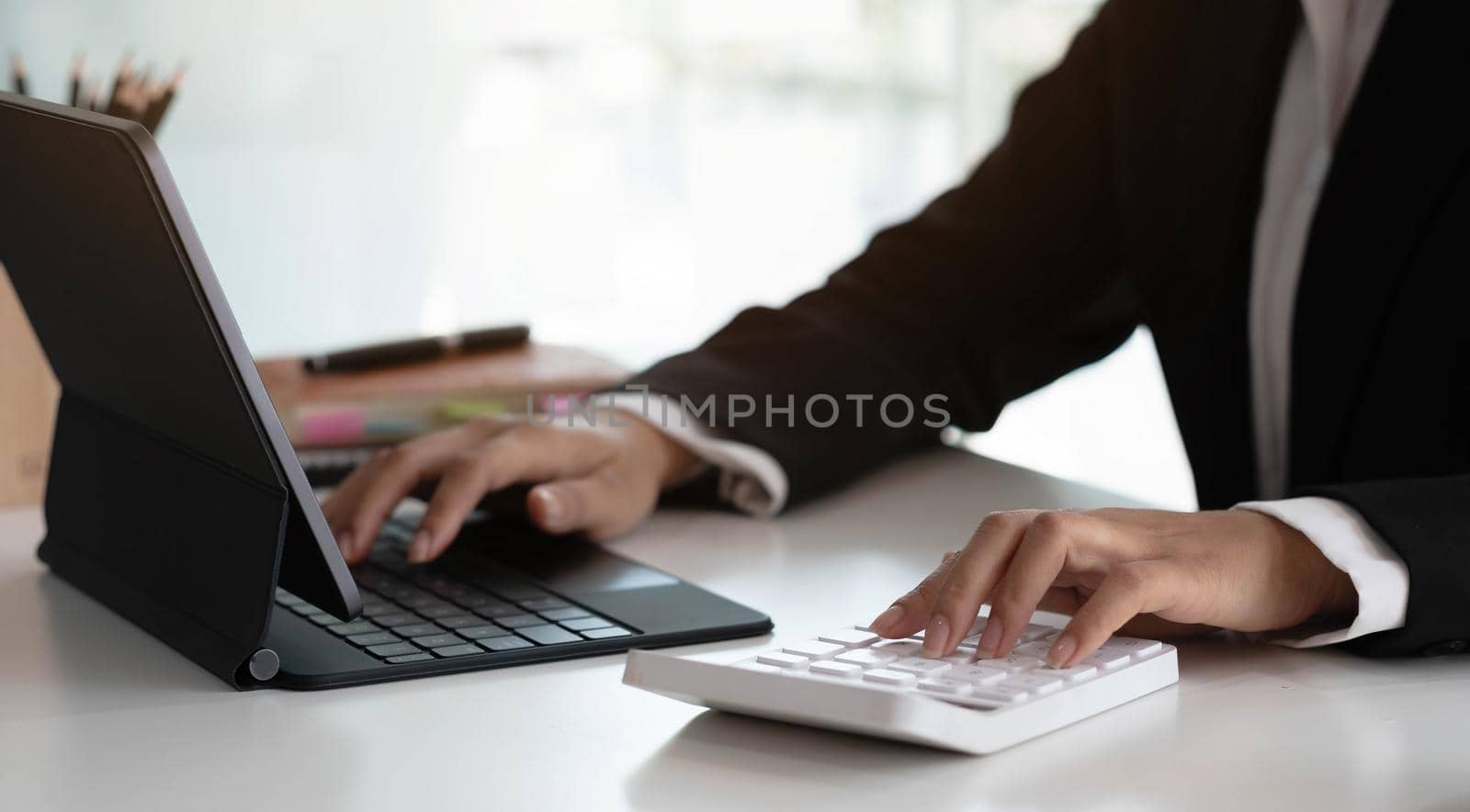 Businesswoman using calculator working at office with laptop reports document financial..