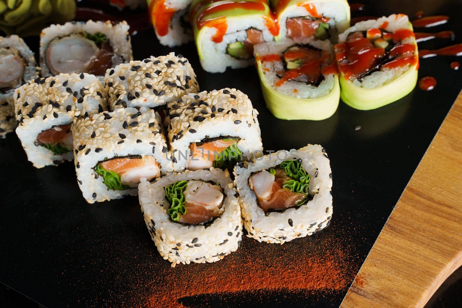 Sushi set close-up on black background. Traditional Japanese seafood. Delicious roll. Advert for food delivery service