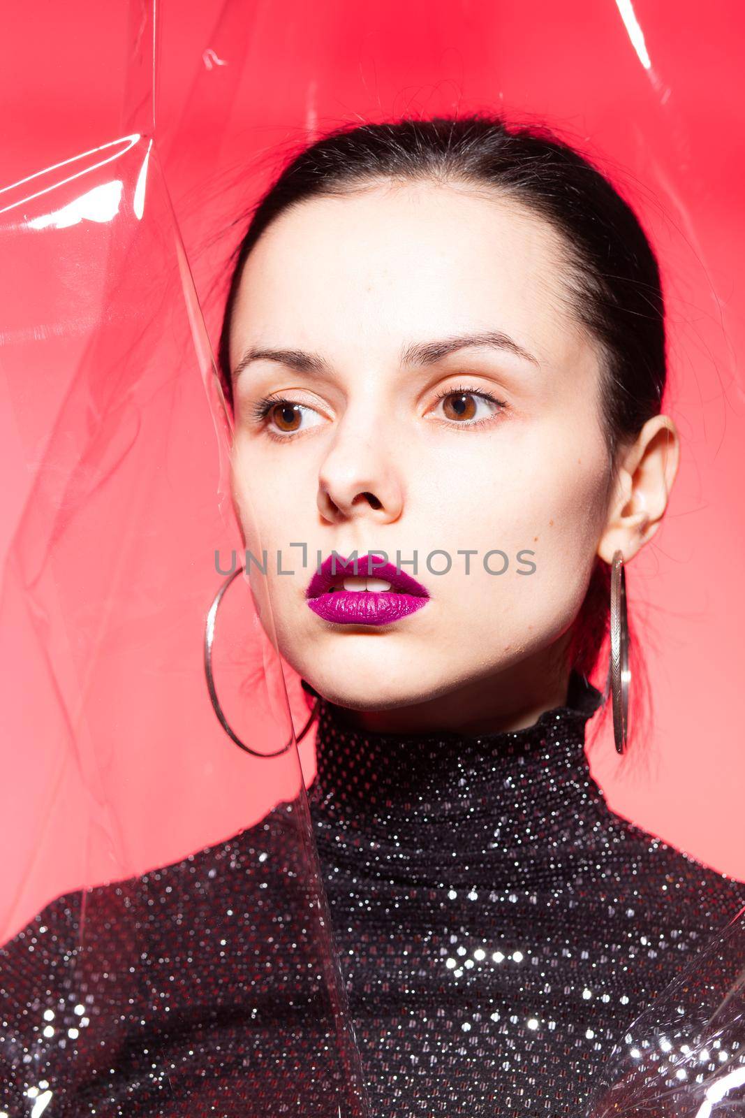 woman with purple lips in a black turtleneck with sequins on a red background by shilovskaya