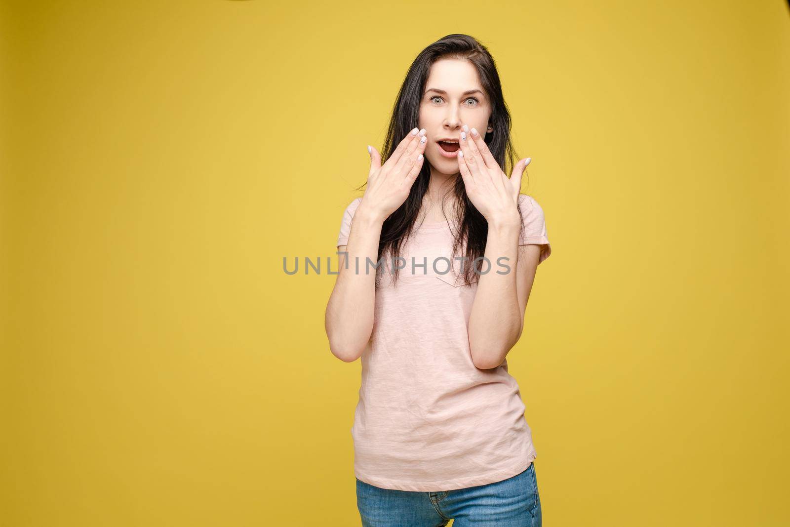 Waist up portrait of surprised beautiful girl with nice long hair, perfect makeup and fashion manicure. She is looking at camera with astonishment. Isolated on dark background