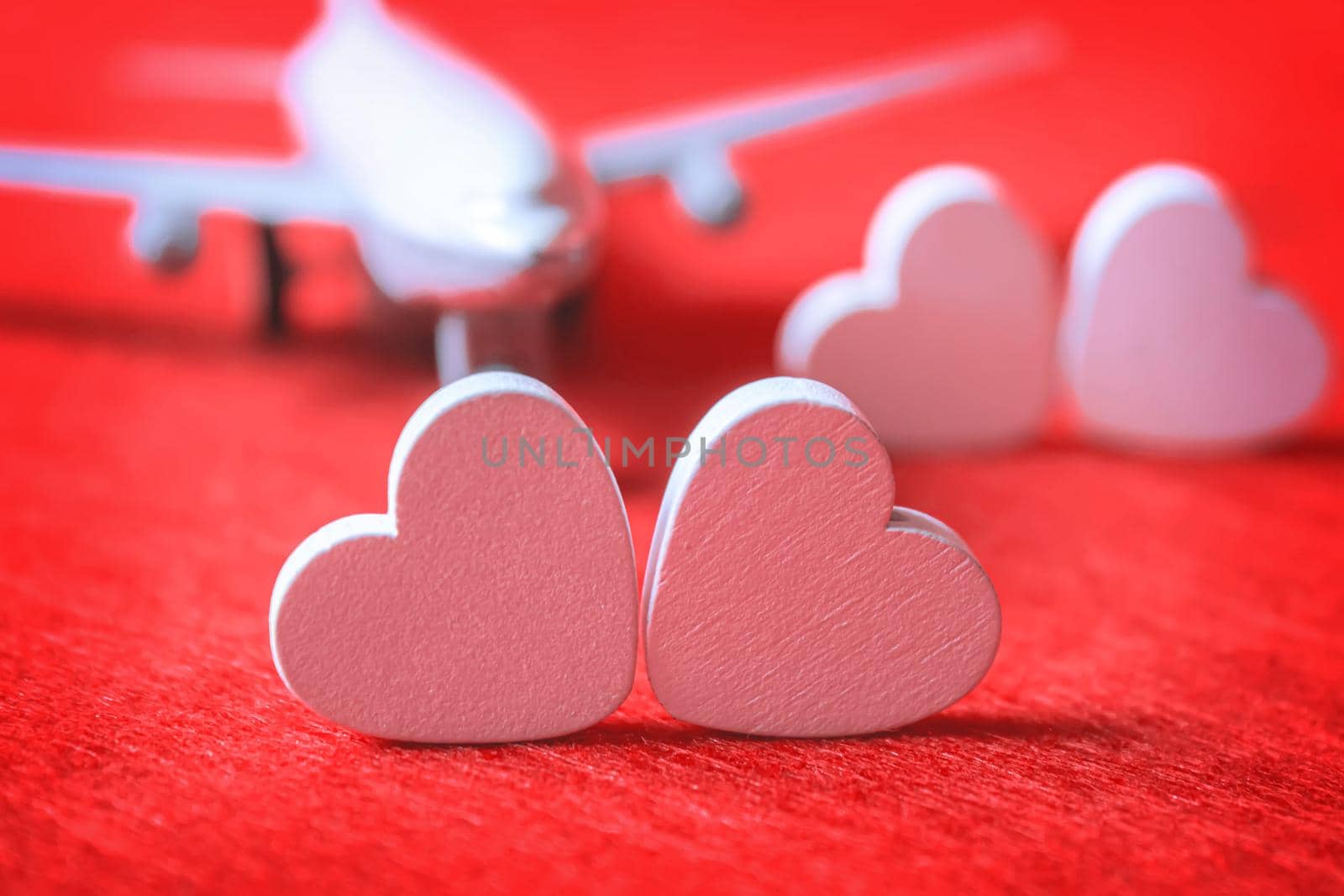 Hearts and a plane on a red background. Valentine's Day. Selective focus. by mila1784