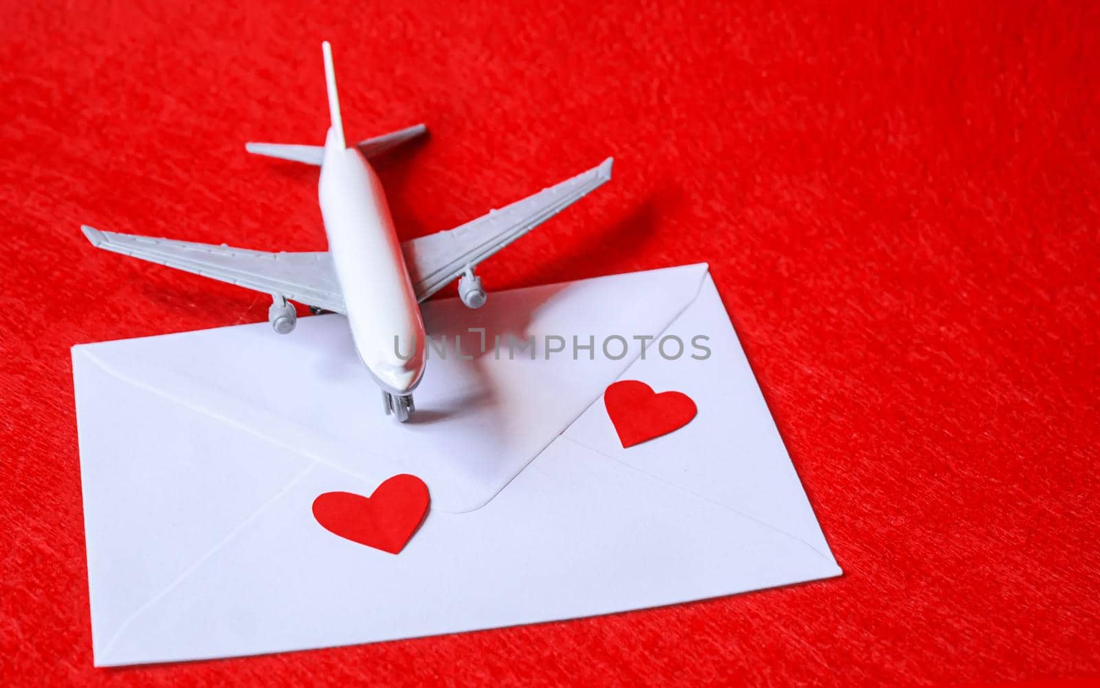 Hearts and a plane on a red background. Valentine's Day. Selective focus. by mila1784