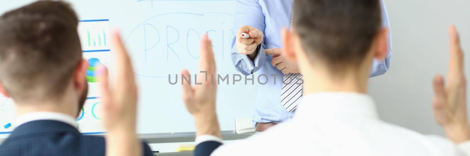 Focus on hand pointing to person wanting to ask something. Workers sitting at office in conference room. Company and business meeting concept. Blurred background