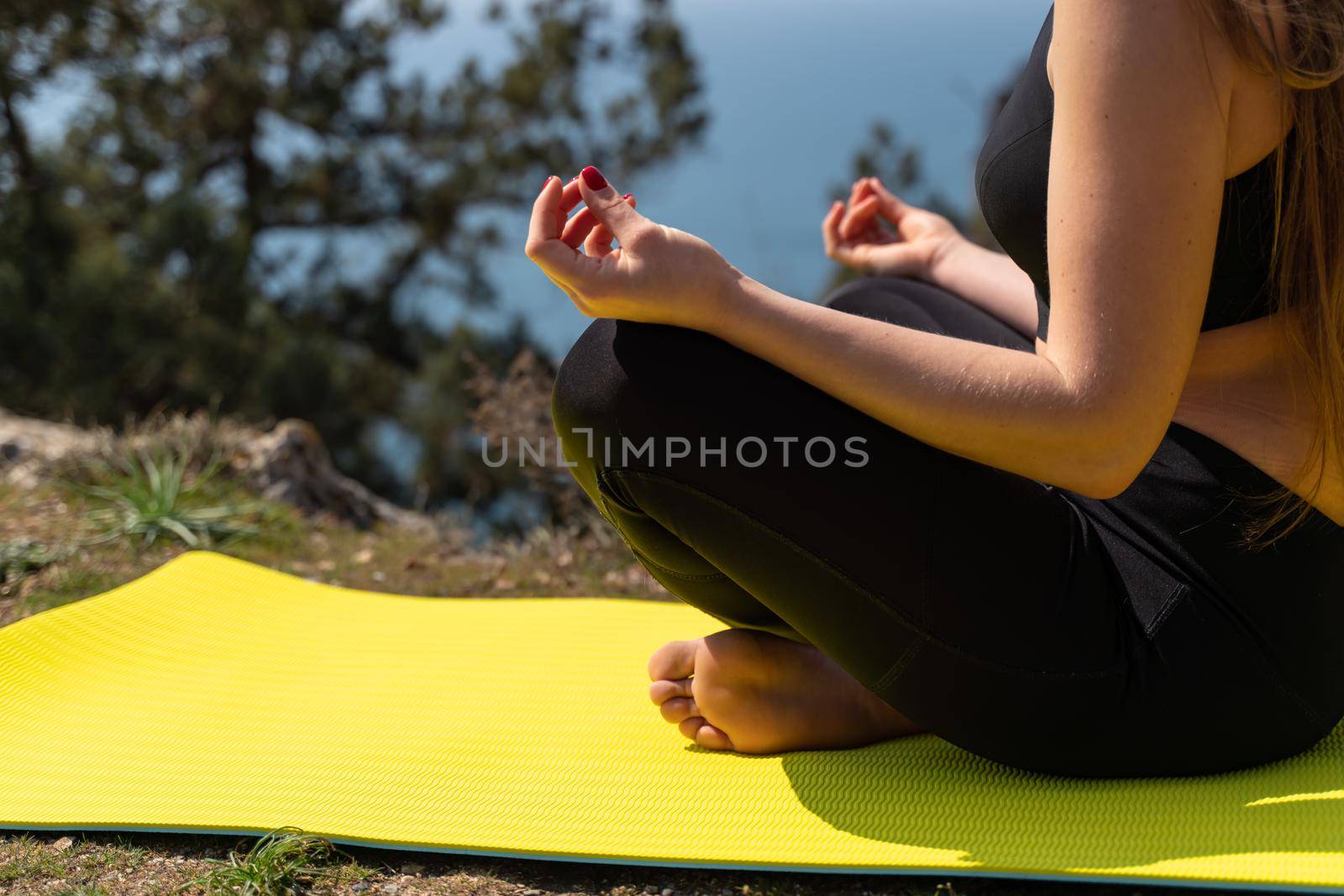 Beautiful woman practicing yoga in the park,Yoga Ardha Padmasana Half lotus pose. by Matiunina