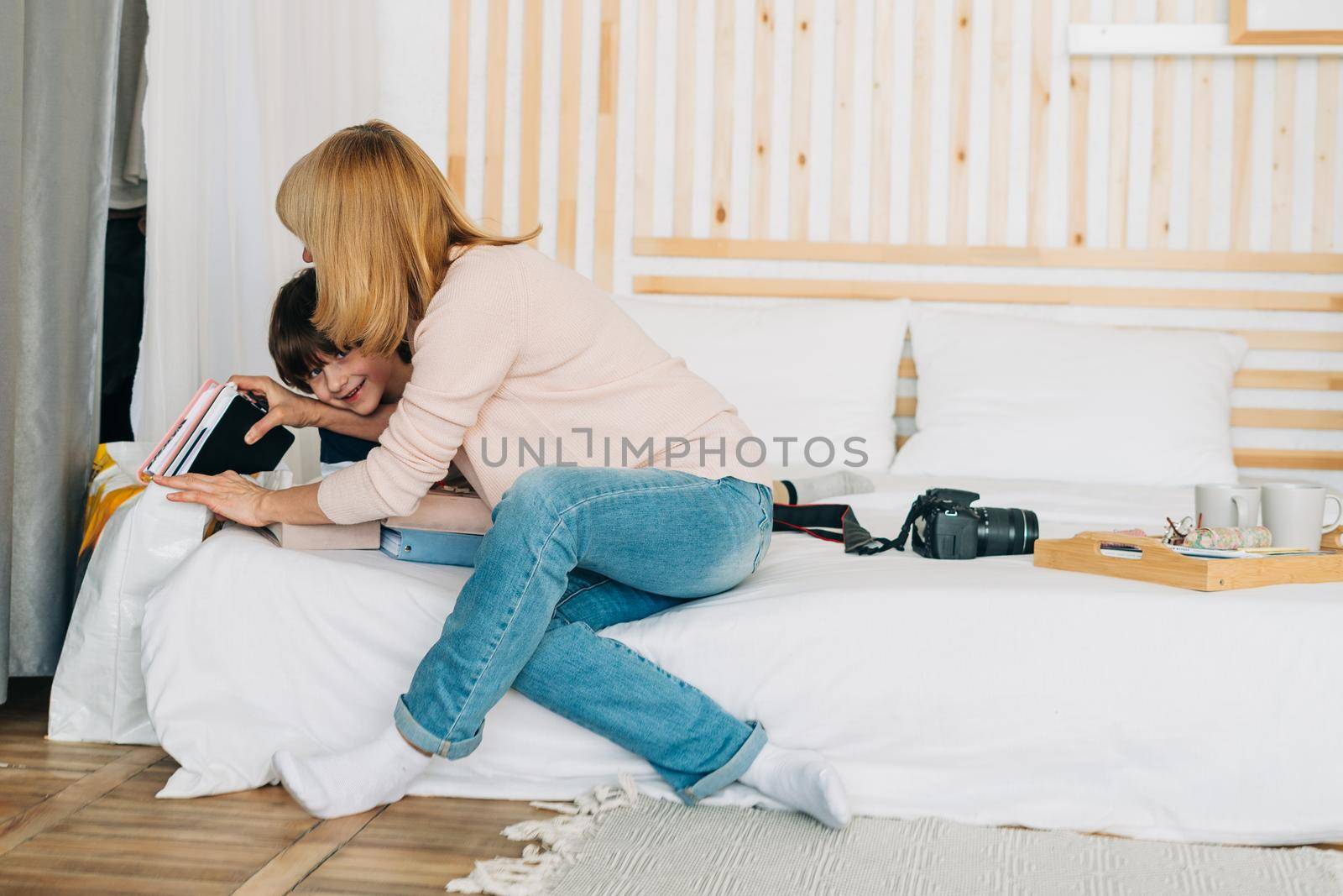 Smiling caucasian school boy kid playing with mom mother on the tablet. Child grandson having fun with his grandmother while playing mobile games on cell phone,