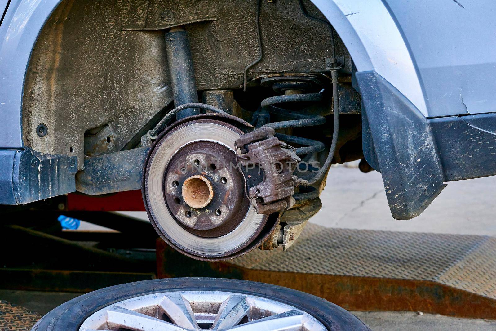 Replacing a car wheel at a tire station. a rubber covering, typically inflated or surrounding an inflated inner tube, placed around a wheel to form a flexible contact with the road.