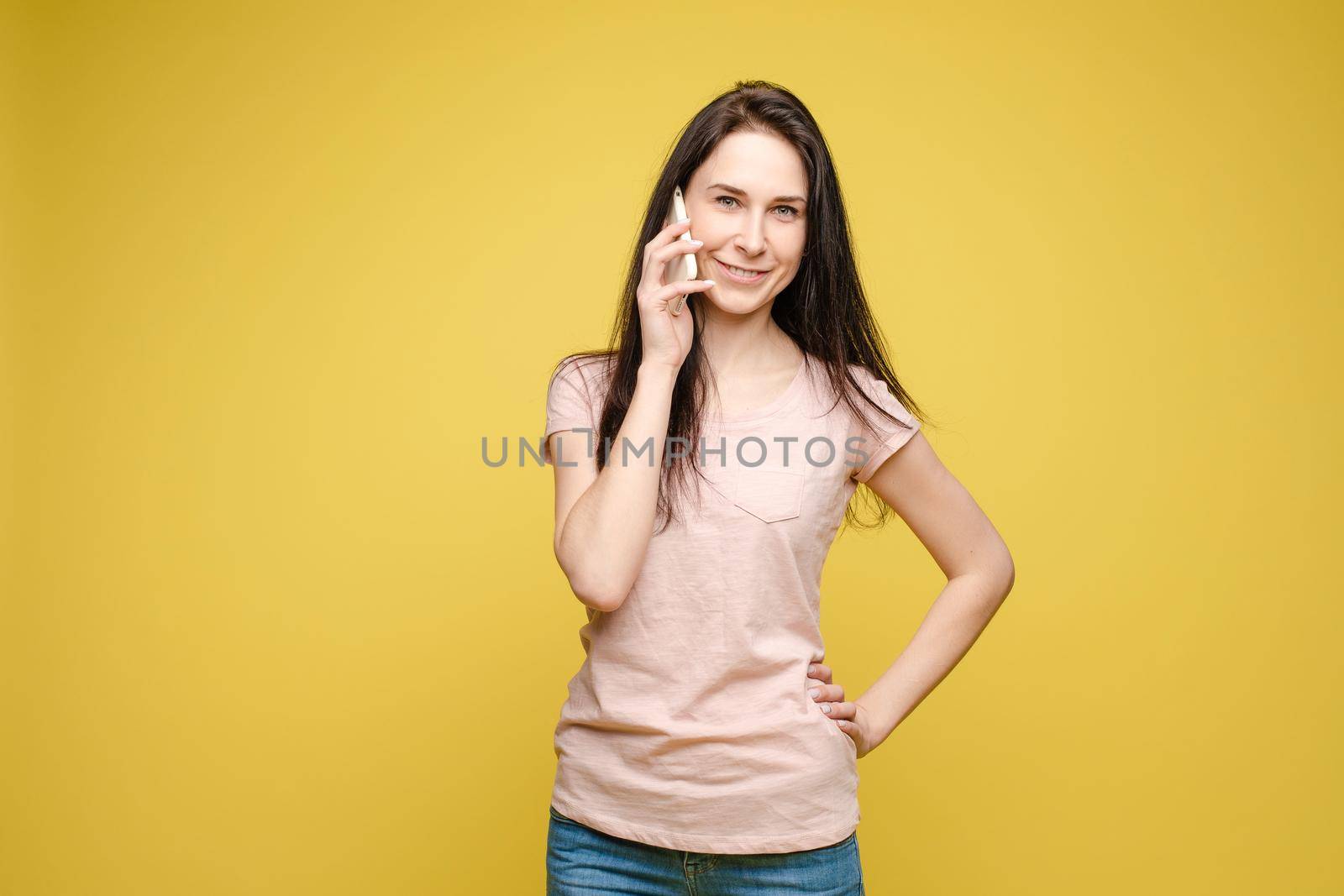 Stylish young girl in bright light dress talking by phone by StudioLucky