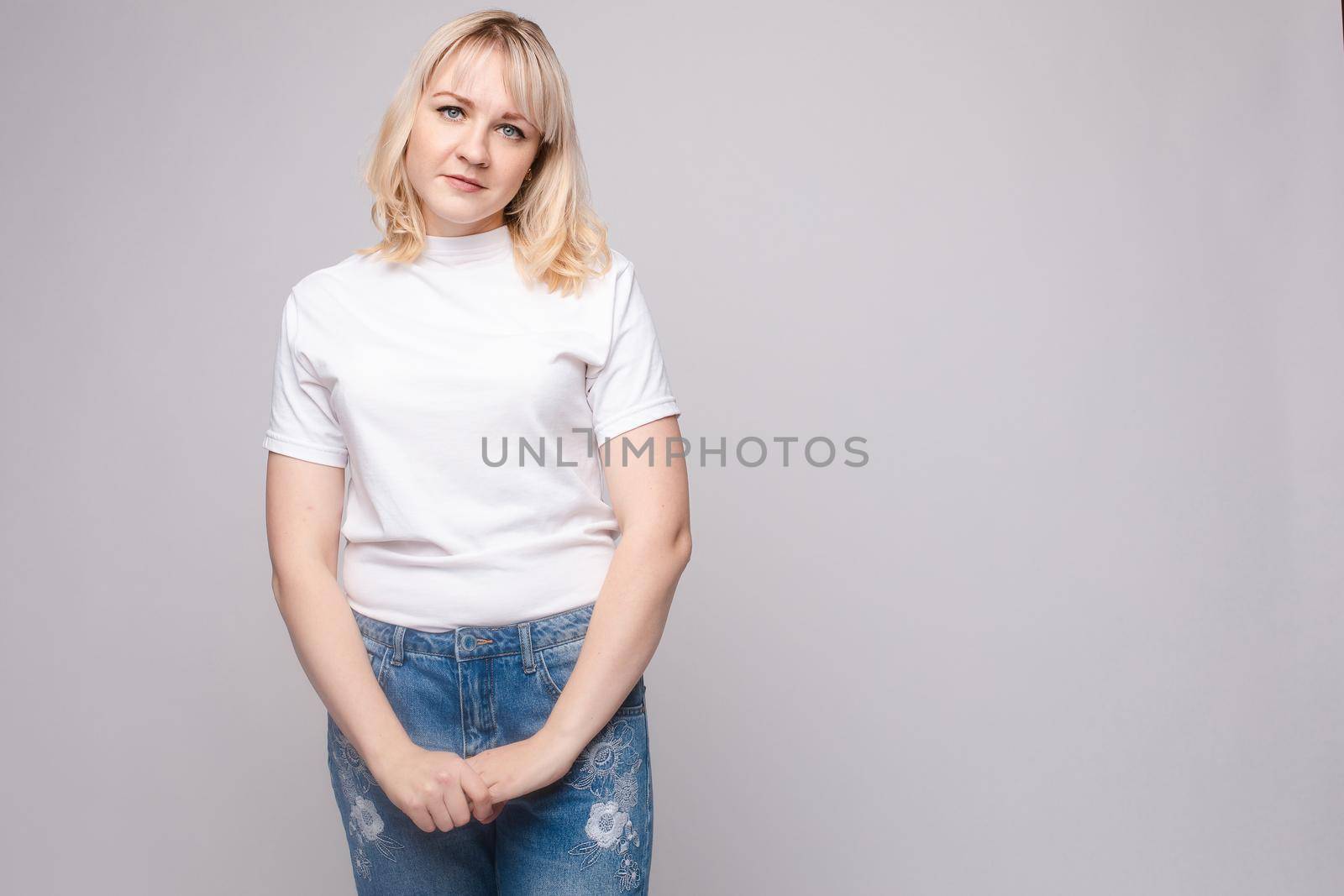 Upset young beautiful woman standing with crossed hands isolated at white studio background by StudioLucky