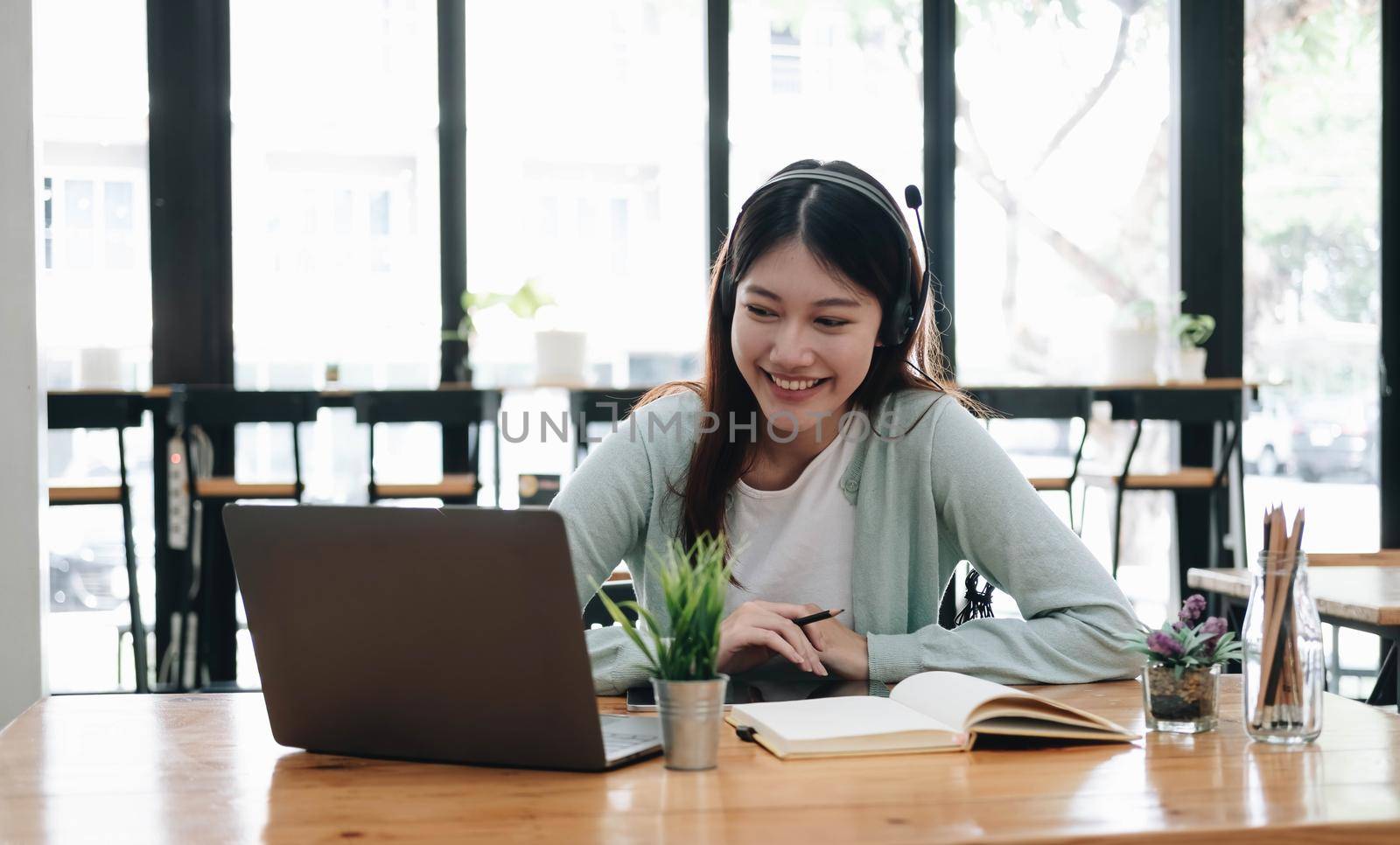 E-learning Online Education concept. Asian woman attentive student student video conference e-learning with teacher on laptop computer at home by wichayada