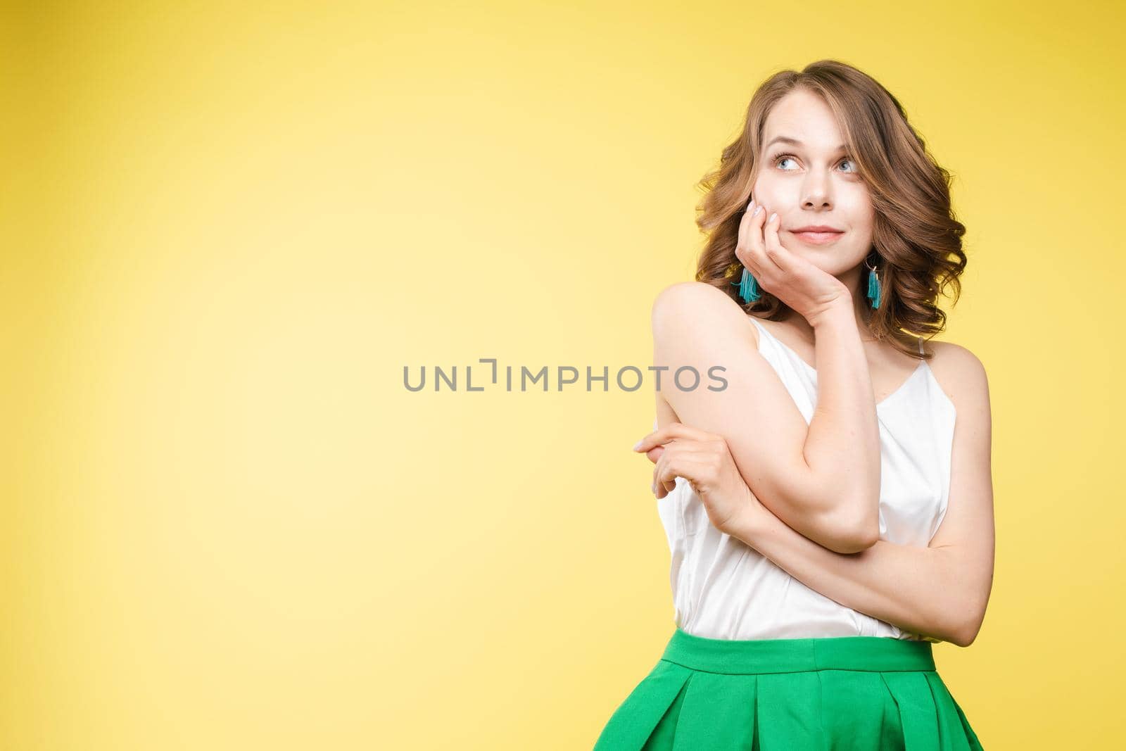 Portrait of happy fashion female with nice hairstyle and beautiful blue eyes posing at studio. Cheerful girl looking away and smiling. Isolated