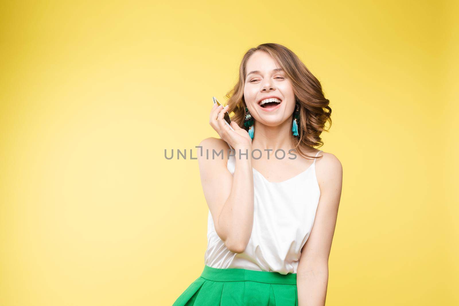 Girl showing mobile to the camera with shocked expression. by StudioLucky