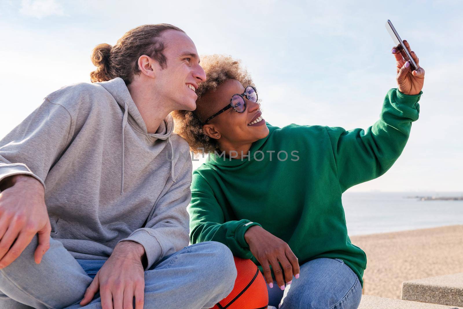 couple of young friends smiling while taking a selfie photo with the mobile phone, concept of friendship and technology