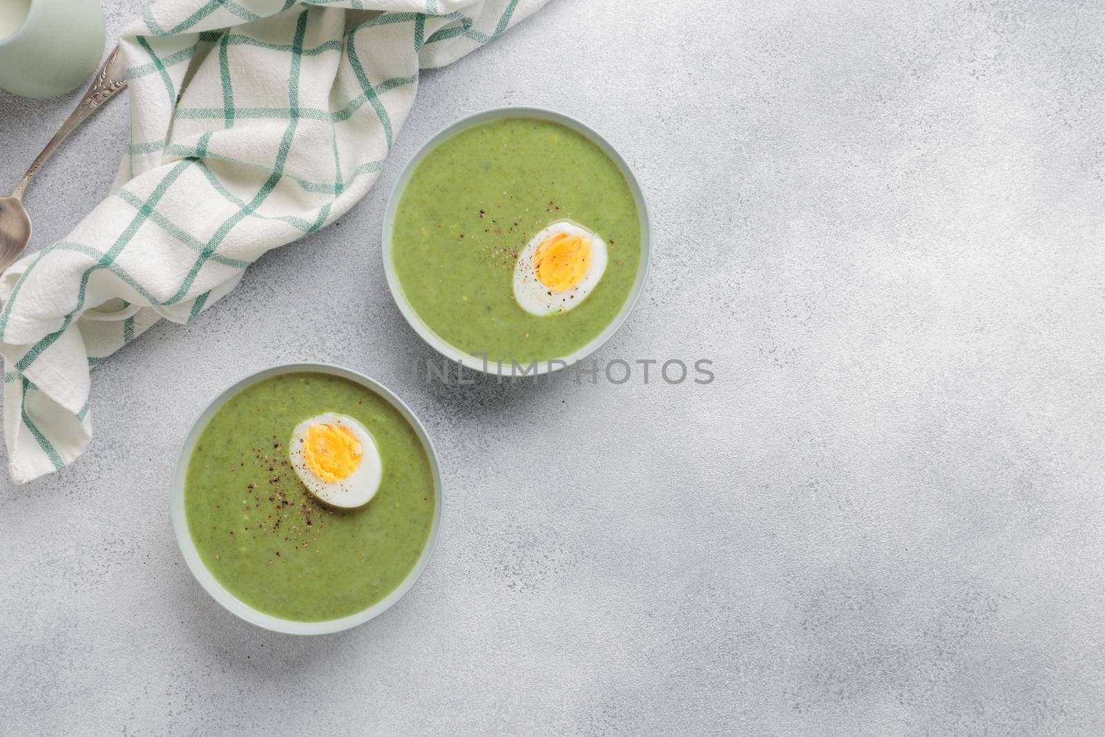 Spinach cream soup with boiled egg top view