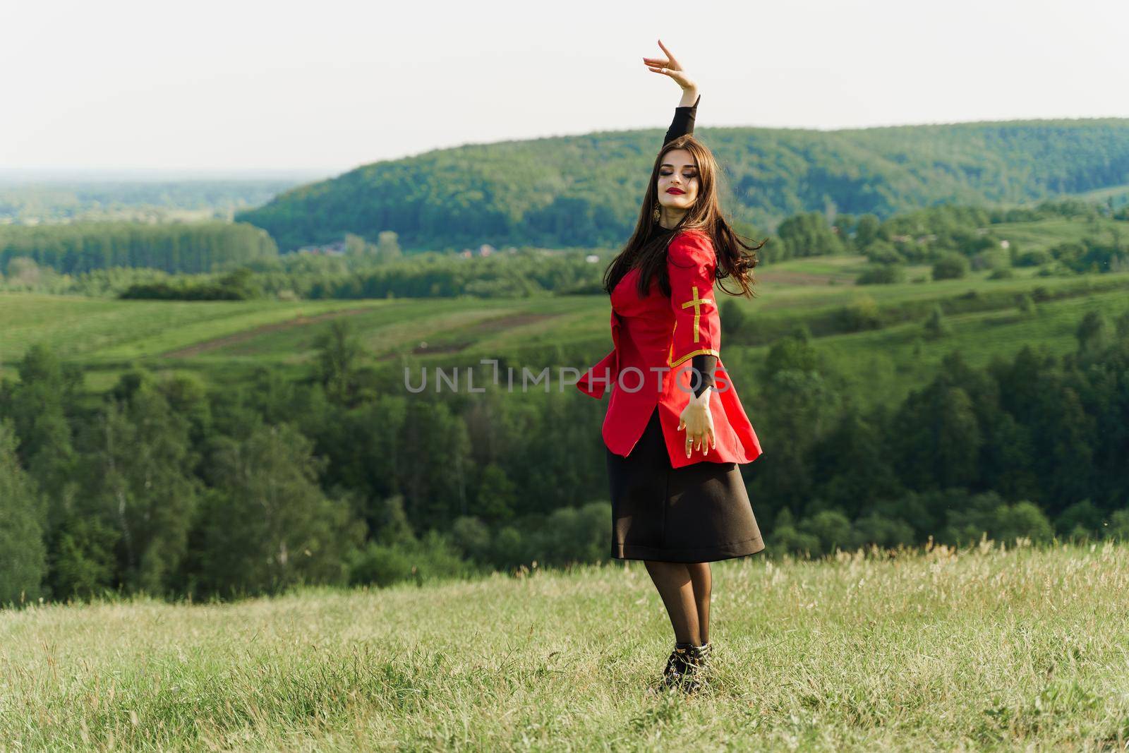 Georgian girl dances national dance in red national dress on the green hills of Georgia background. Georgian culture lifestyle by Rabizo