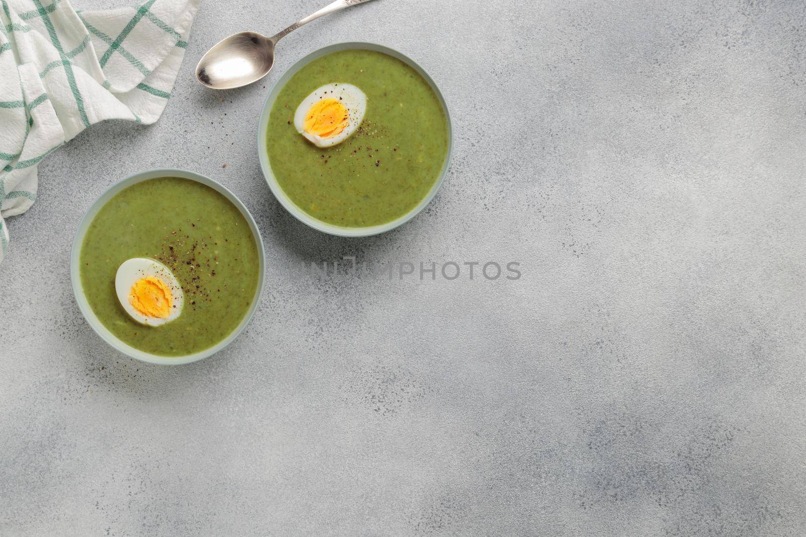 Spinach cream soup with boiled egg top view