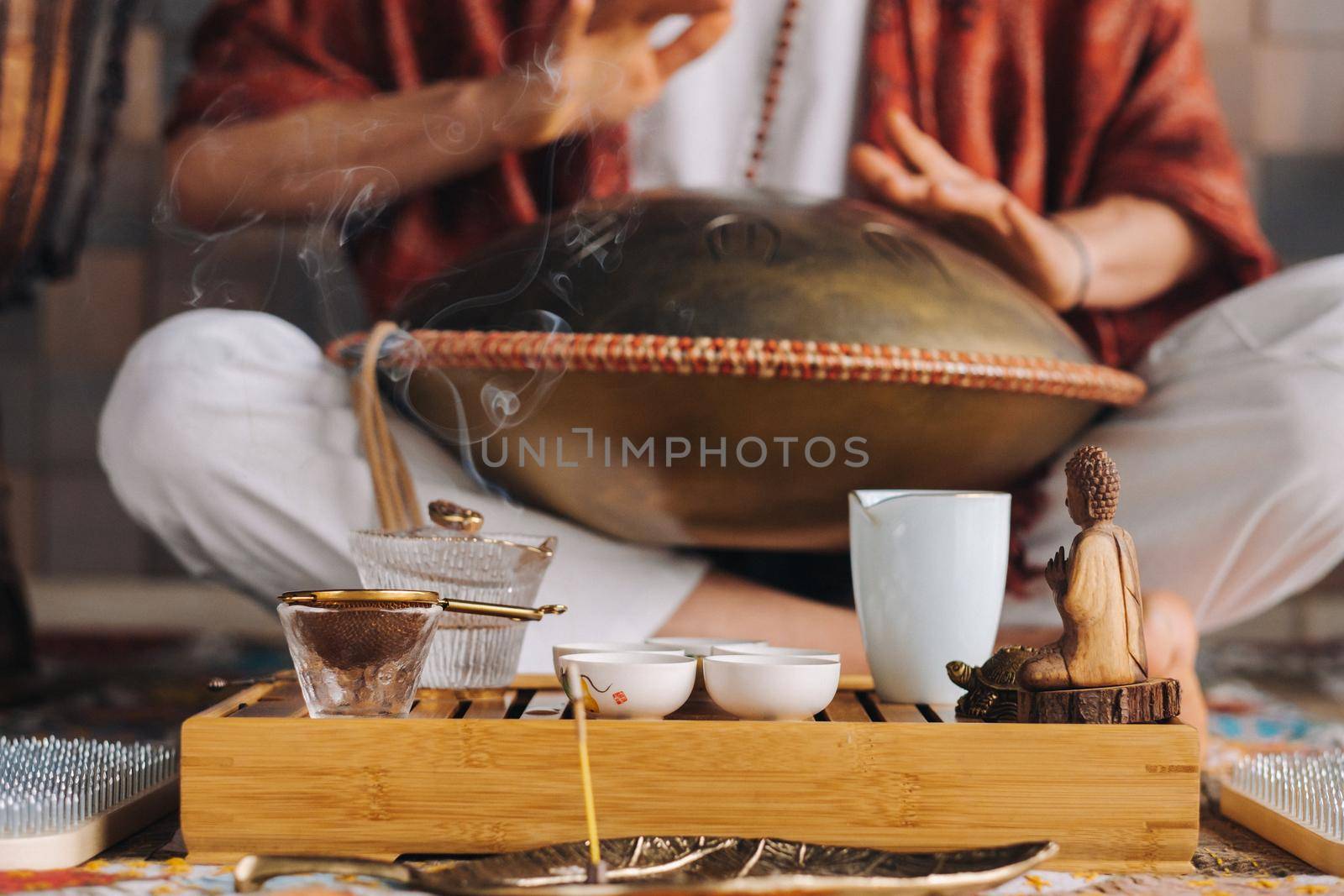 Close-up of a man's hand playing a modern musical instrument - the Orion tongue drum during the tea ceremony.