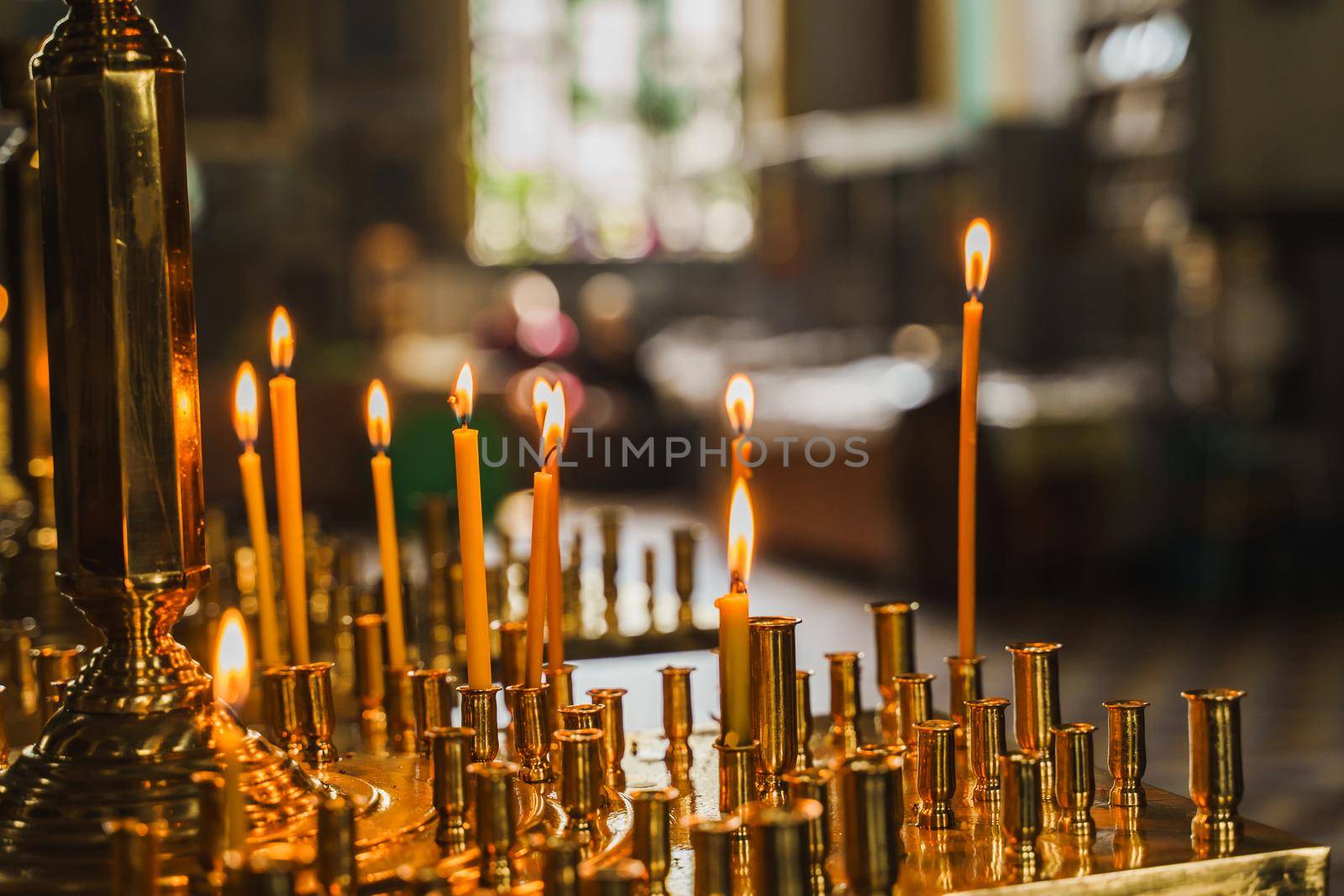 Candelabrum with burnings candles in church. Orthodox tradition and faith. Equipment for praying. Pray for people life. Pray to god