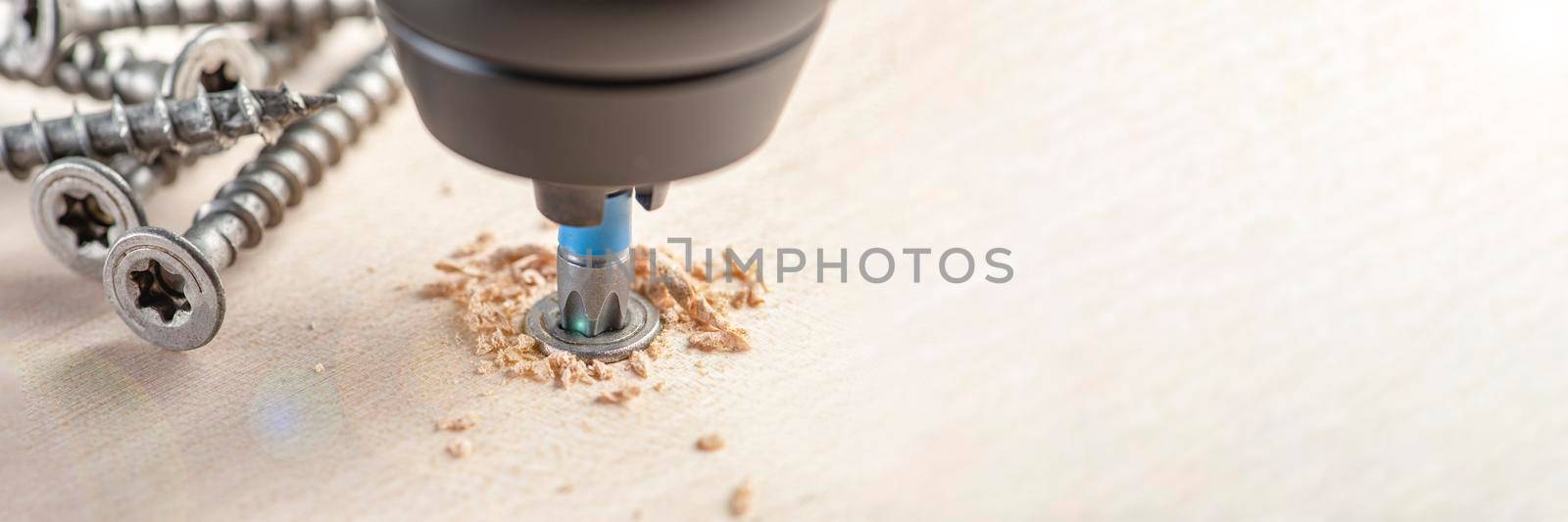 Manufacture of wooden furniture. Driving a screw into a piece of furniture. Assembling wooden furniture close-up.