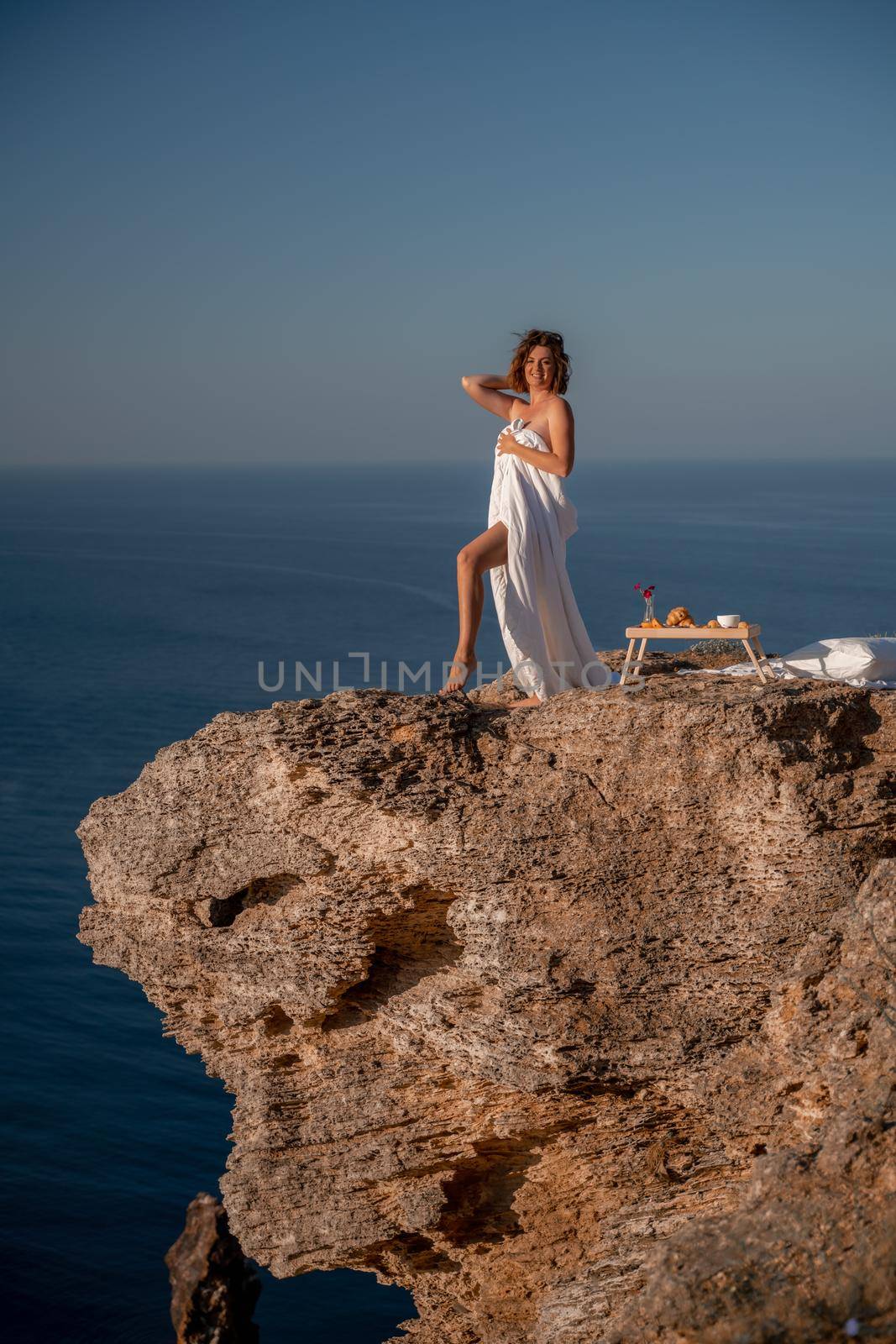 Woman wake up in bed wuth duvet and pillow over nature sea background outdoors. Back view. Good morning. Freedom concept. by Matiunina