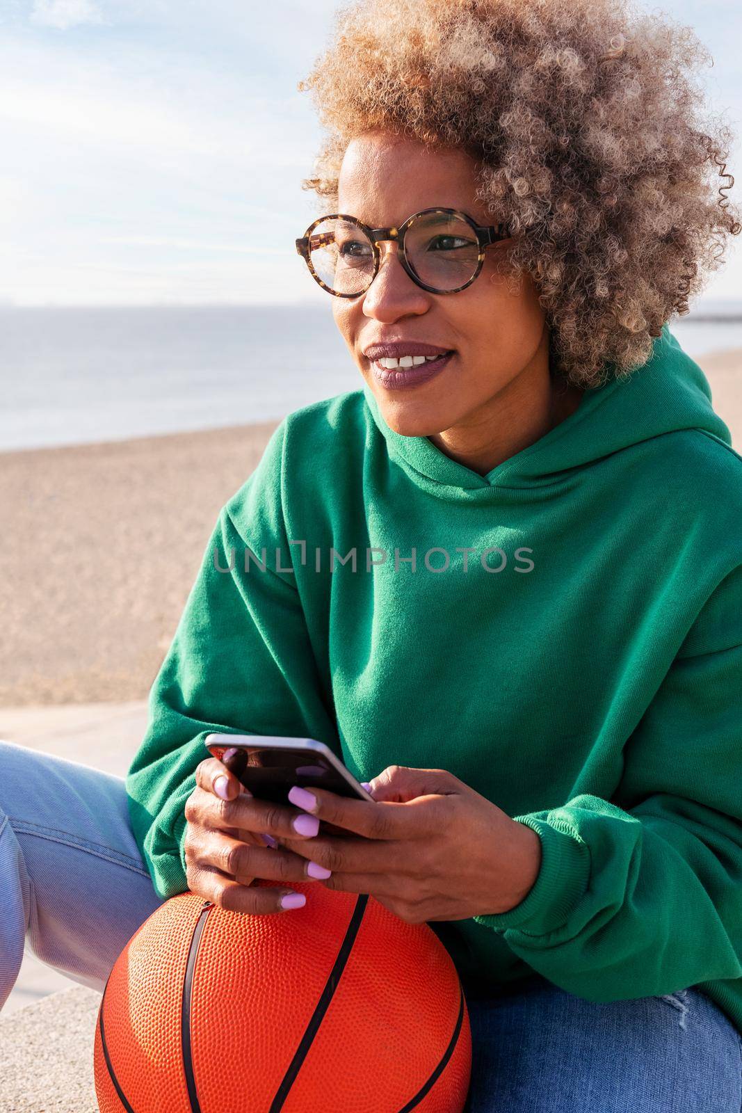 vertical photo of a young latin woman using her phone outdoors, concept of lifestyle and technology of communication