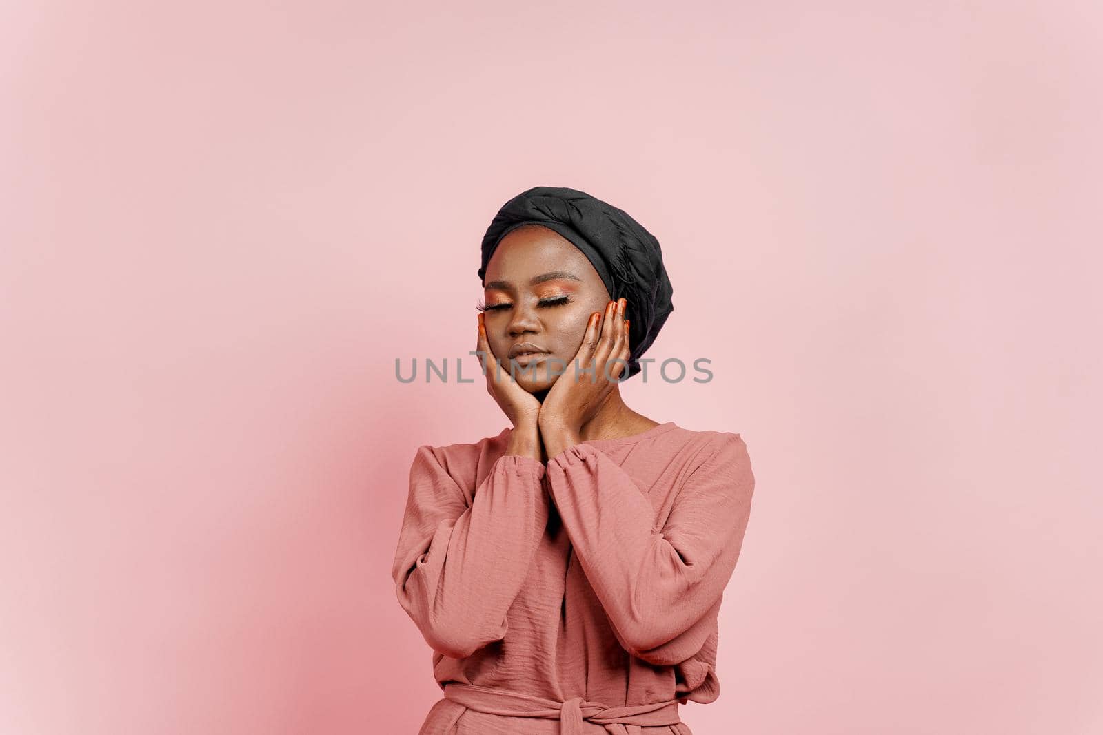 Muslim young woman weared in traditional dress and scarf touches her face and relax. Relaxation and meditation with yoga.