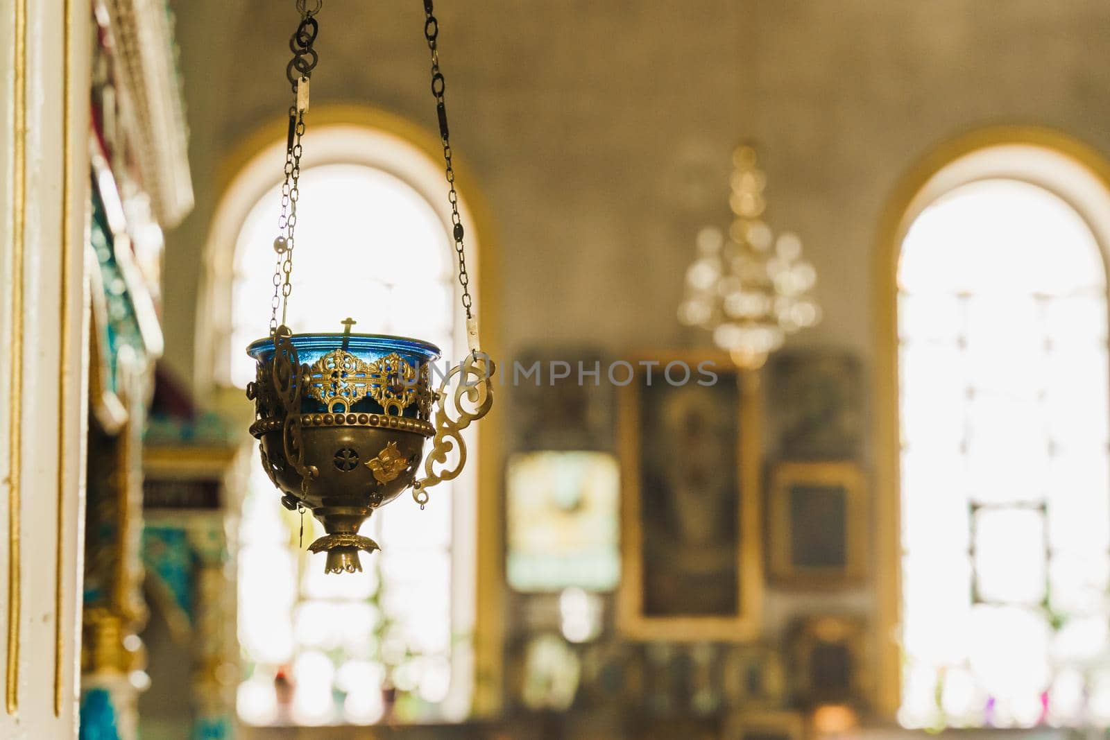 Gold censer with a bleue candlestick in the church. Big chandelier on the background. Church interior. Equipment for praying. Pray for people life. Pray to god