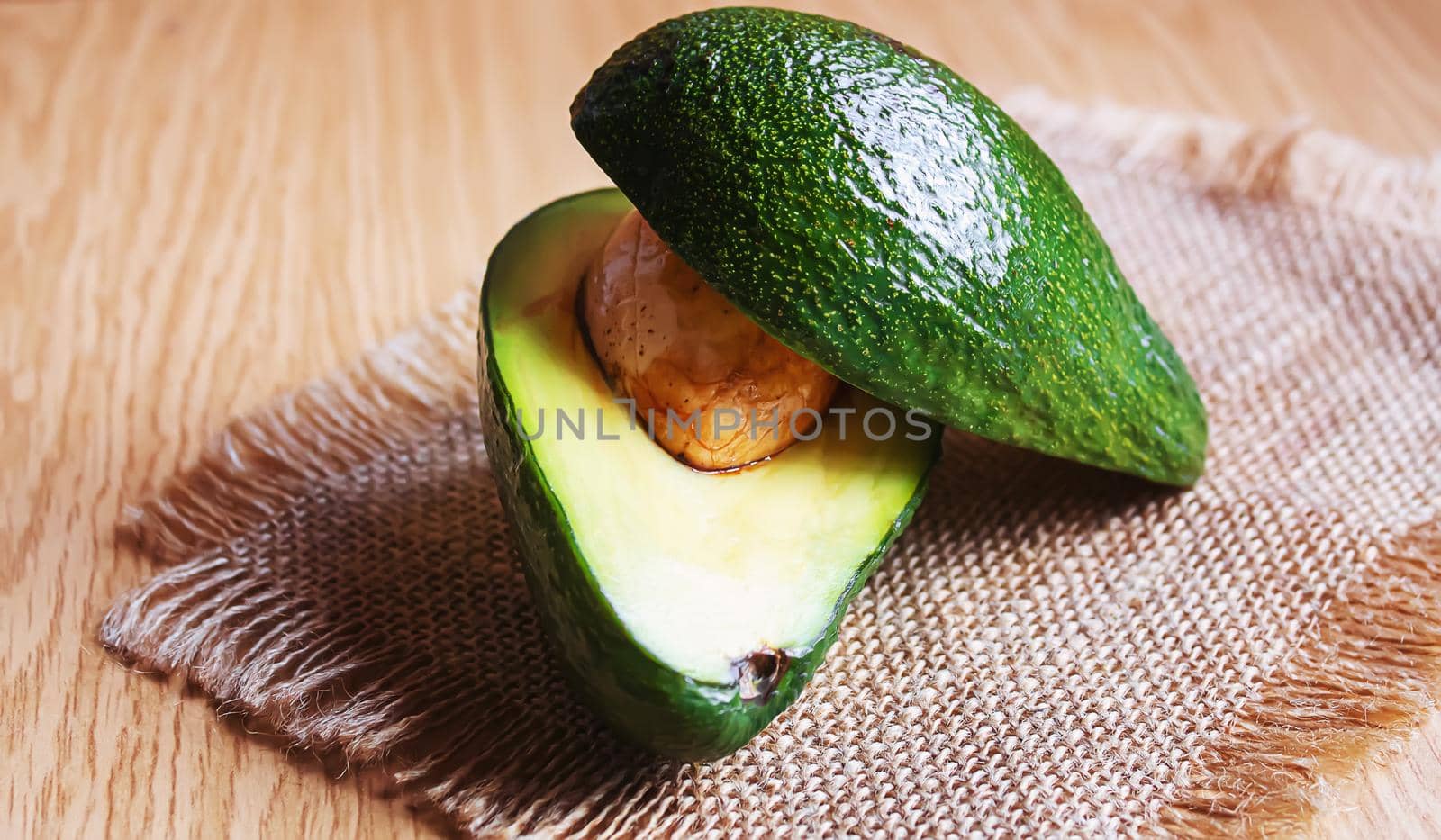 Avocado and avocado oil on wooden background. Selective focus. by mila1784
