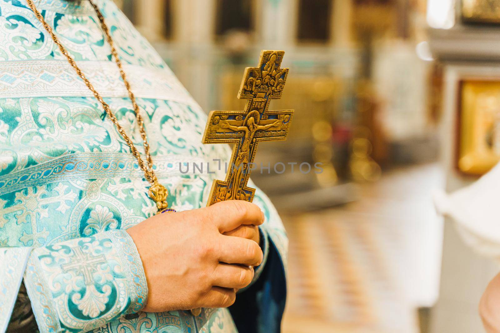 Holy father in his robe with a golden cross in his hands in church. Orthodox tradition and faith. Equipment for praying. Pray for people life. Pray to god