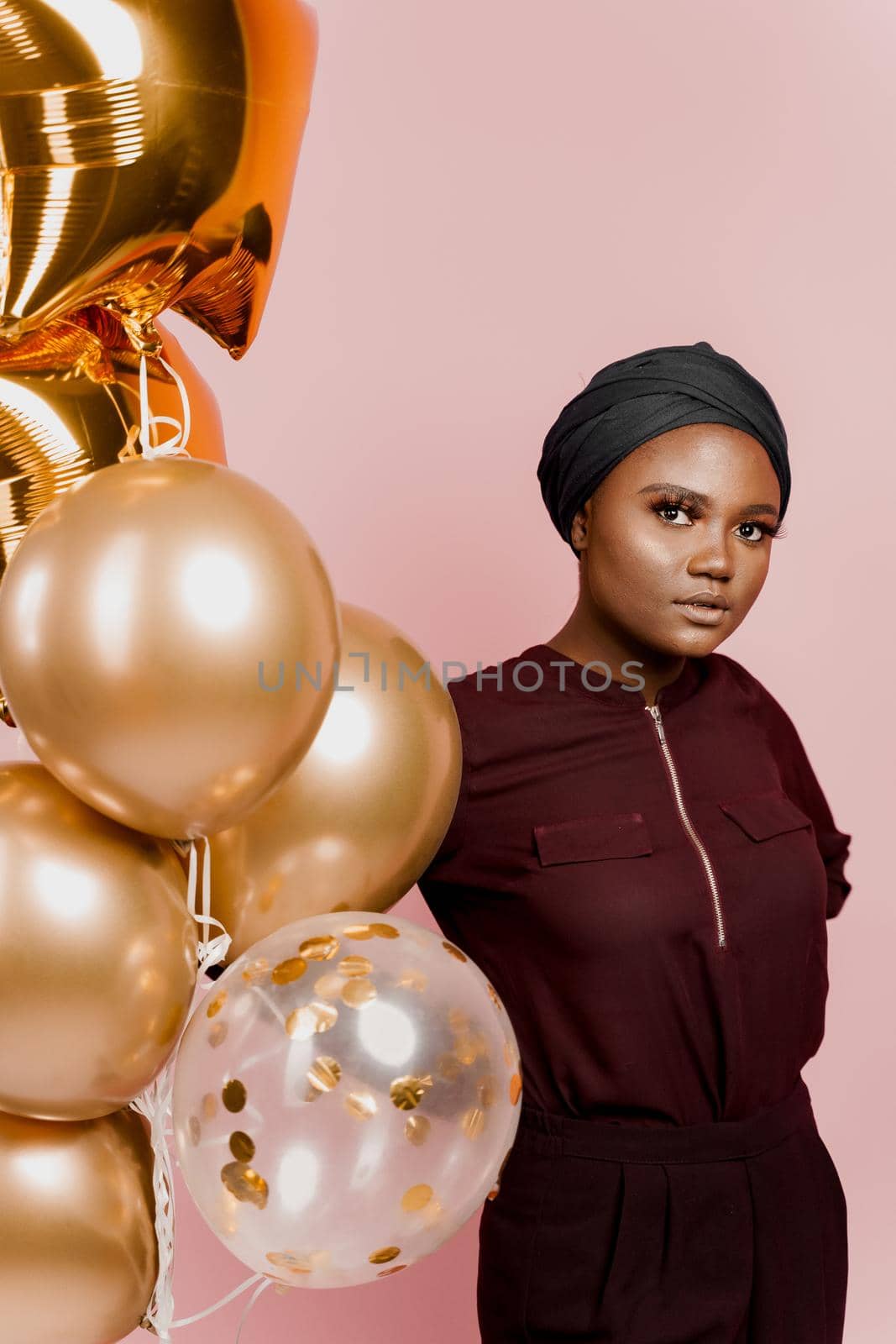 Muslim new year party with golden balloons for black woman. African attractive girl celebration of the end of year. Happy emotion. by Rabizo