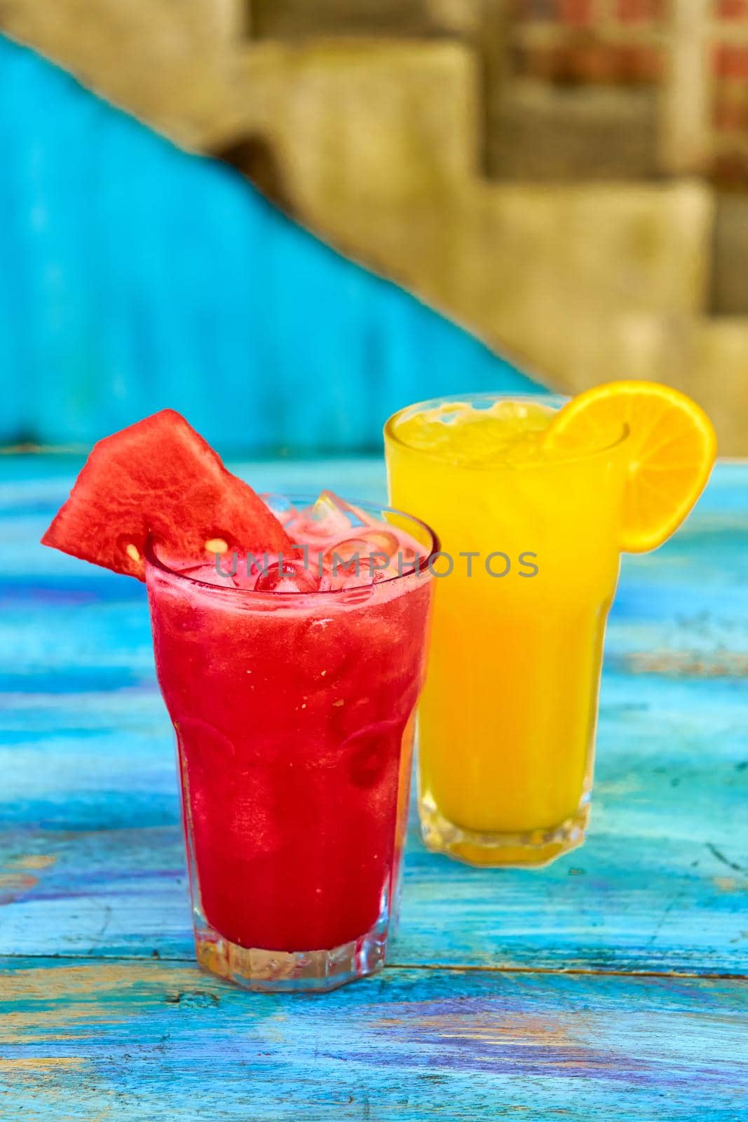 Two glass glasses with refreshing drinks from orange and watermelon juice