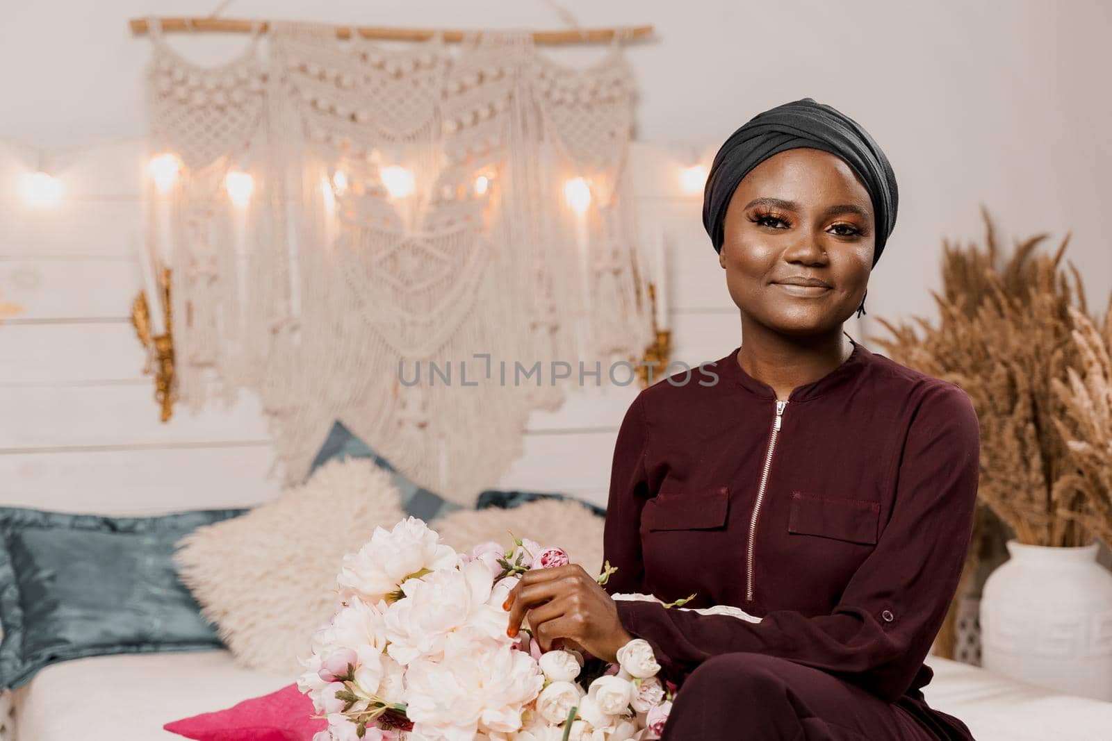 Muslim girl with bouquet of flowers from her boyfriend on the valentines day. Holiday celebration. Happy african woman smiles. by Rabizo