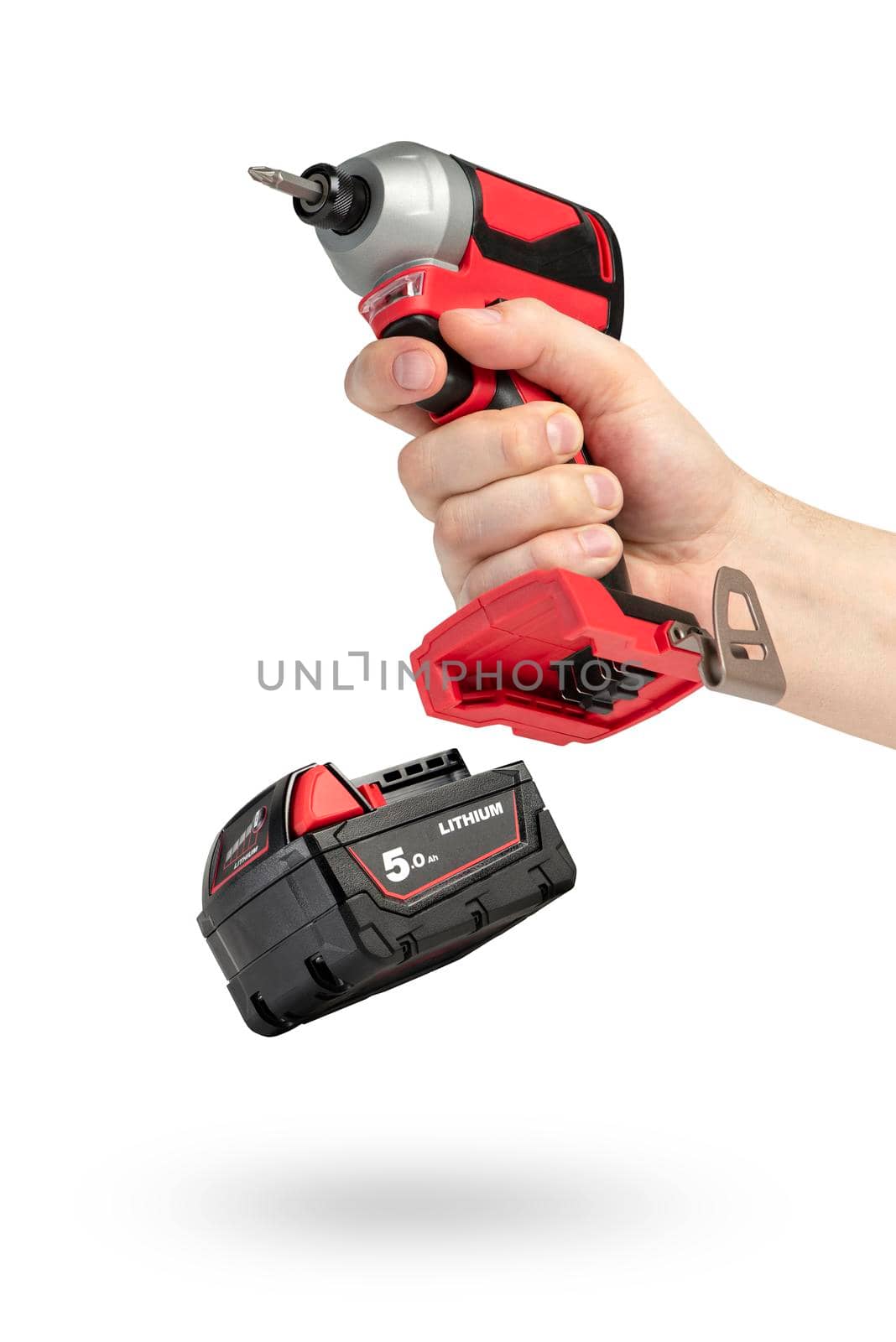 Drill in hand on a white isolated background. Cordless drill or screwdriver in a male hand. Removable lithium battery casts a shadow. The concept of selling and using cordless tools. by SERSOL