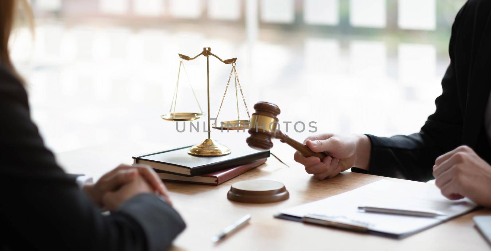 Business and lawyers discussing contract papers with brass scale on desk in office. Law, legal services, advice, justice and law concept picture with film grain effect by wichayada