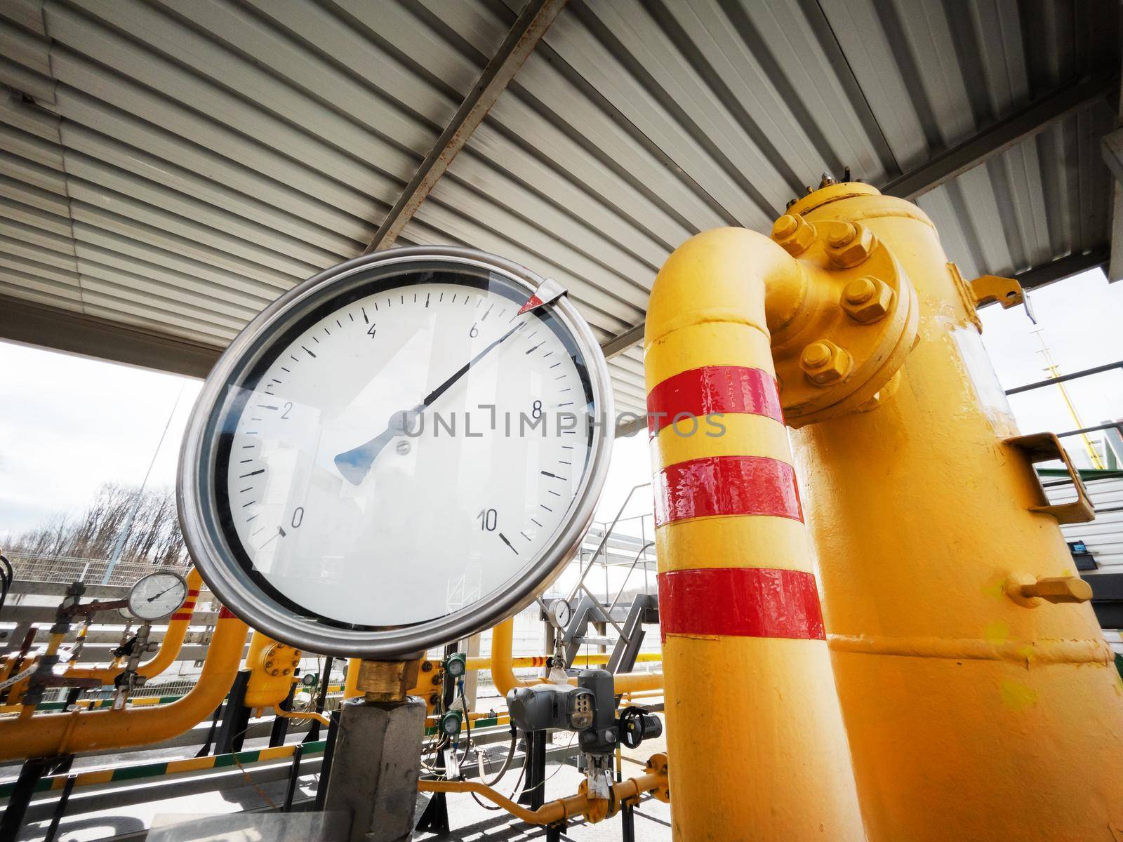 Yellow gas pipeline with a large pressure gauge for measuring gas pressure to generate energy