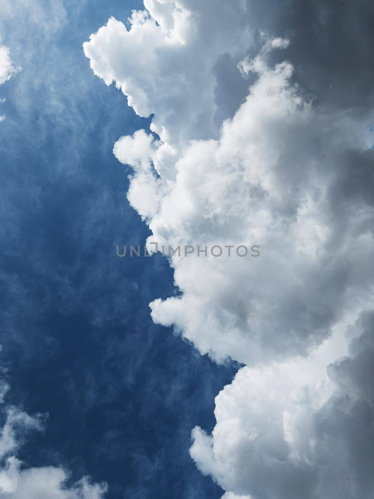 Cumulus clouds diagonally against a dark blue sky with free space