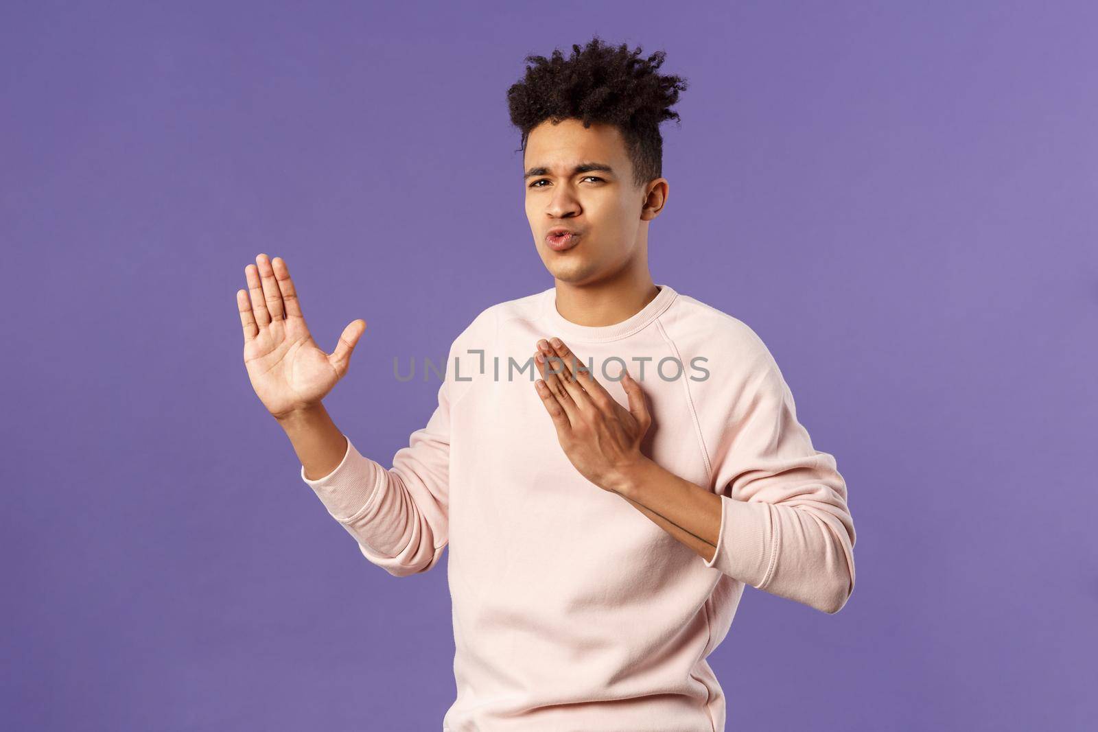 Portrait of funny and carefree young hispanic guy holding hands in martial arts attack pose, folding lips acting sassy and cool as imitating ninja, ready to defeat coronavirus, purple background by Benzoix