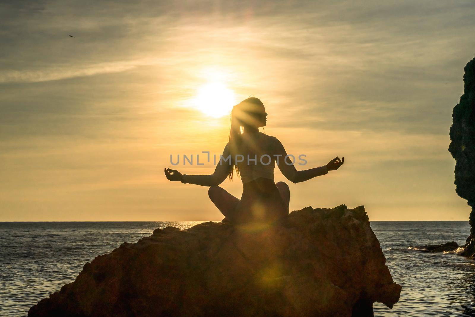 Young woman practicing yoga outdoors. Harmony and meditation concept. Healthy lifestyle by Matiunina